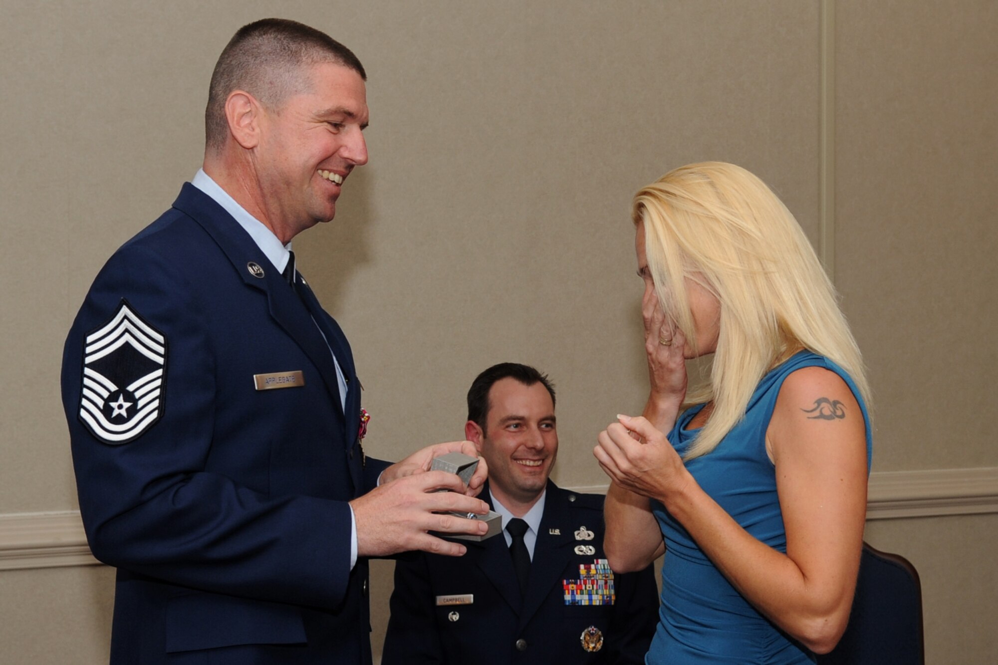 U.S. Air Force Senior Master Sgt. Sean Applegate watches the reaction of his wife, Monique Applegate, after presenting her with a new wedding ring, during his promotion ceremony to Chief Master Sergeant at Langley Air Force Base, Va., May 31, 2012. Chief master sergeants make up the top one percent of the enlisted ranks of the Air Force, and epitomize the finest qualities of a military leader. (U.S. Air Force photo by Airman 1st Class Racheal Watson/Released)