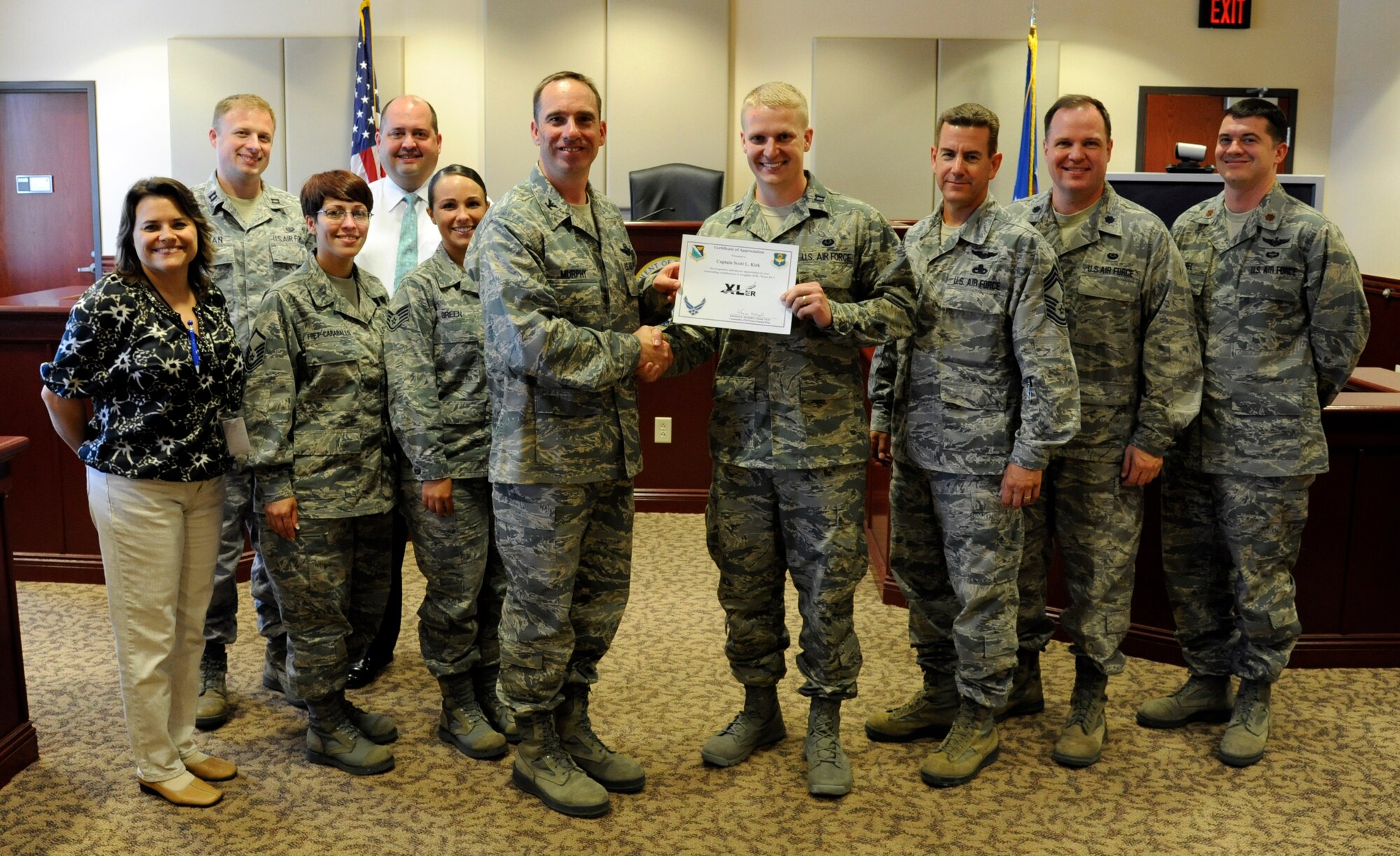 Capt. Scott Kirk, 47th Flying Training Wing chief of legal assistance, poses with Col. Tom Murphy, 47th Flying Training Wing commander, and Chief Master Sgt. Dean Ferris, 47th Operations Group superintendant, after being presented the XLer of the week award at Laughlin Air Force Base, Texas, May 30, 2012. The XLer is a weekly award chosen by wing leadership and given to those who consistently make outstanding contributions to Laughlin and their unit. (U.S. Air Force photo/Airman 1st Class Nathan Maysonet)