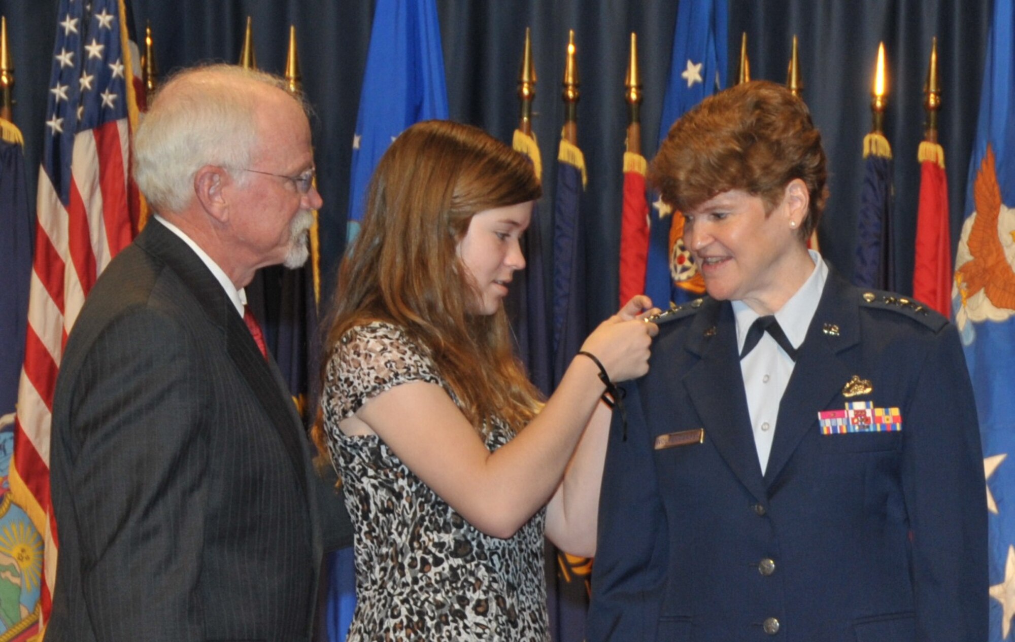 Gen. Janet C. Wolfenbarger is pinned with her fourth star by her daughter, Callie, and her husband, retired Col. Craig Wolfenbarger, during a promotion ceremony June 5, 2012, at the National Museum of the United States Air Force. The promotion makes Gen. Wolfenbarger the first four-star general in the Air Force.  (U.S. Air Force photo/Michelle Gigante)