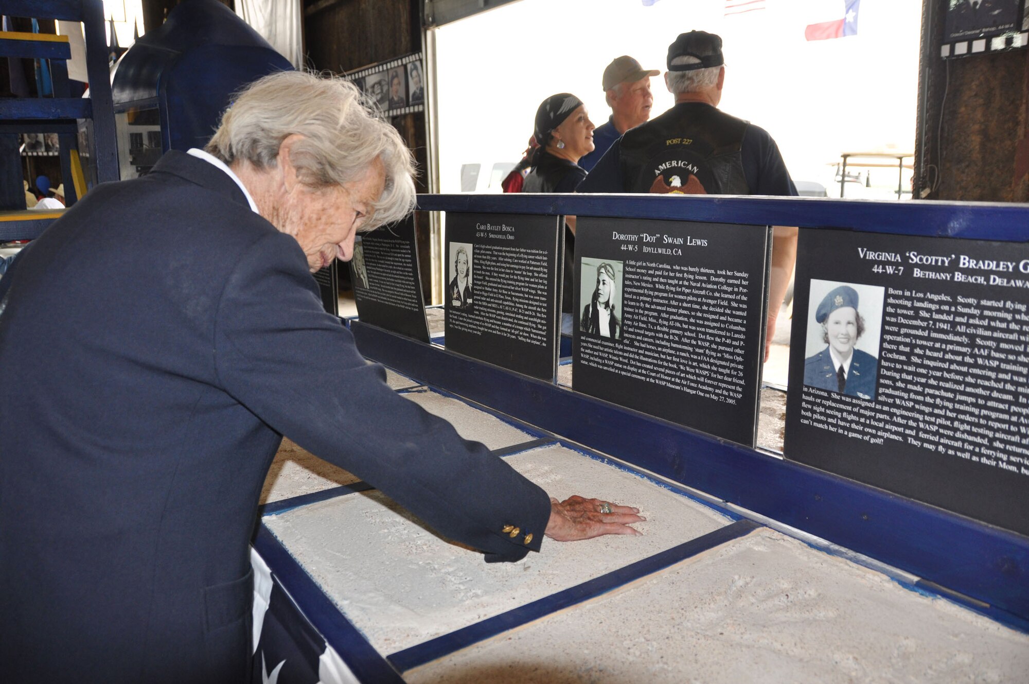 SWEETWATER, Texas -- WASP Dorothy "Dot" Swain Lewis reminisces as she places her hand in a concrete mold of her handprints inside the Avenger Field hangar May 26. Lewis was a primary instructor at Avenger Field before joining the WASP program as a trainee. Upon graduation, she was stationed at Columbus Army Air Field, Miss.,and Laredo Army Air Base, Texas, flying AT-10s, P-40s, P-63s and B-26s. (U.S. Air Force photo/Maj. Jessica Martin)