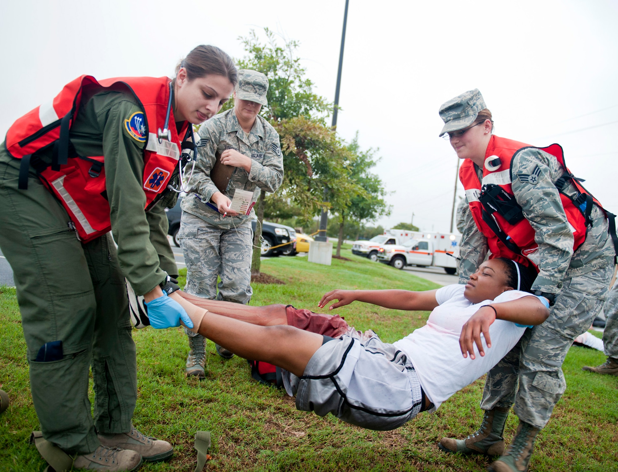 Capt. Susan Marchiano and Senior Airman Jennifer Lewis lift Senior Airman Shatavia Wallace to transport on a litter during a mass casualty exercise Sept. 23, 2011, at Moody Air Force Base, Ga. Marchiano is the 347th Operations Support Squadron flight surgeon, Lewis is a 23rd Aerospace Medicine Squadron medical technician and Wallace is an 824th Base Defense Squadron fire team member. (U.S. Air Force photo/Staff Sgt. Jamal D. Sutter)