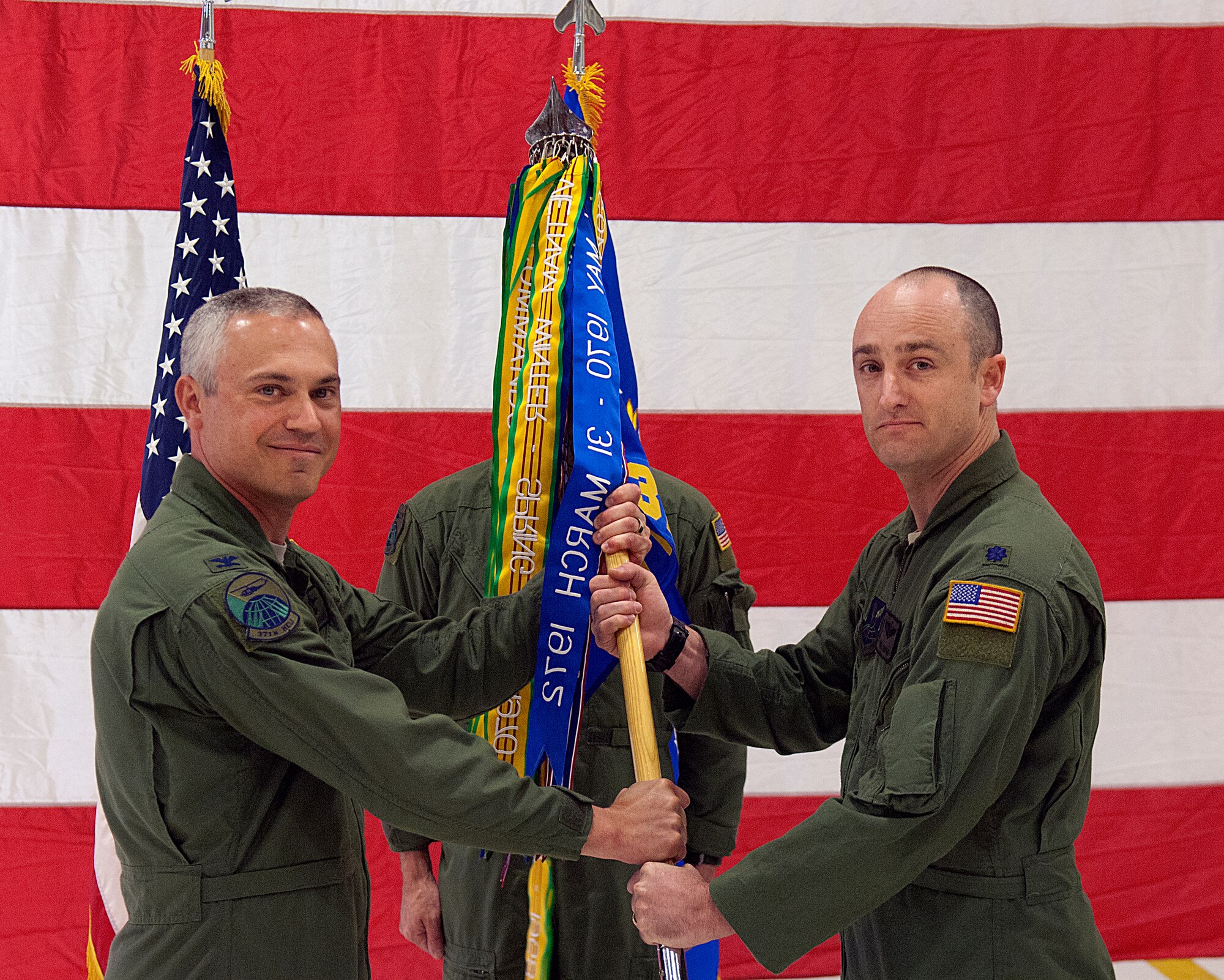 Col. Robert Vercher, 90th Operations Group commander, hands Lt. Col. Philip Cooper the 37th Helicopter Squadron guidon as Cooper assumes command of the squadron during a change of command ceremony May 24, in the squadron’s hanger on F. E. Warren Air Force Base, Wyo. (U.S. Air Force photo by R.J. Oriez) 