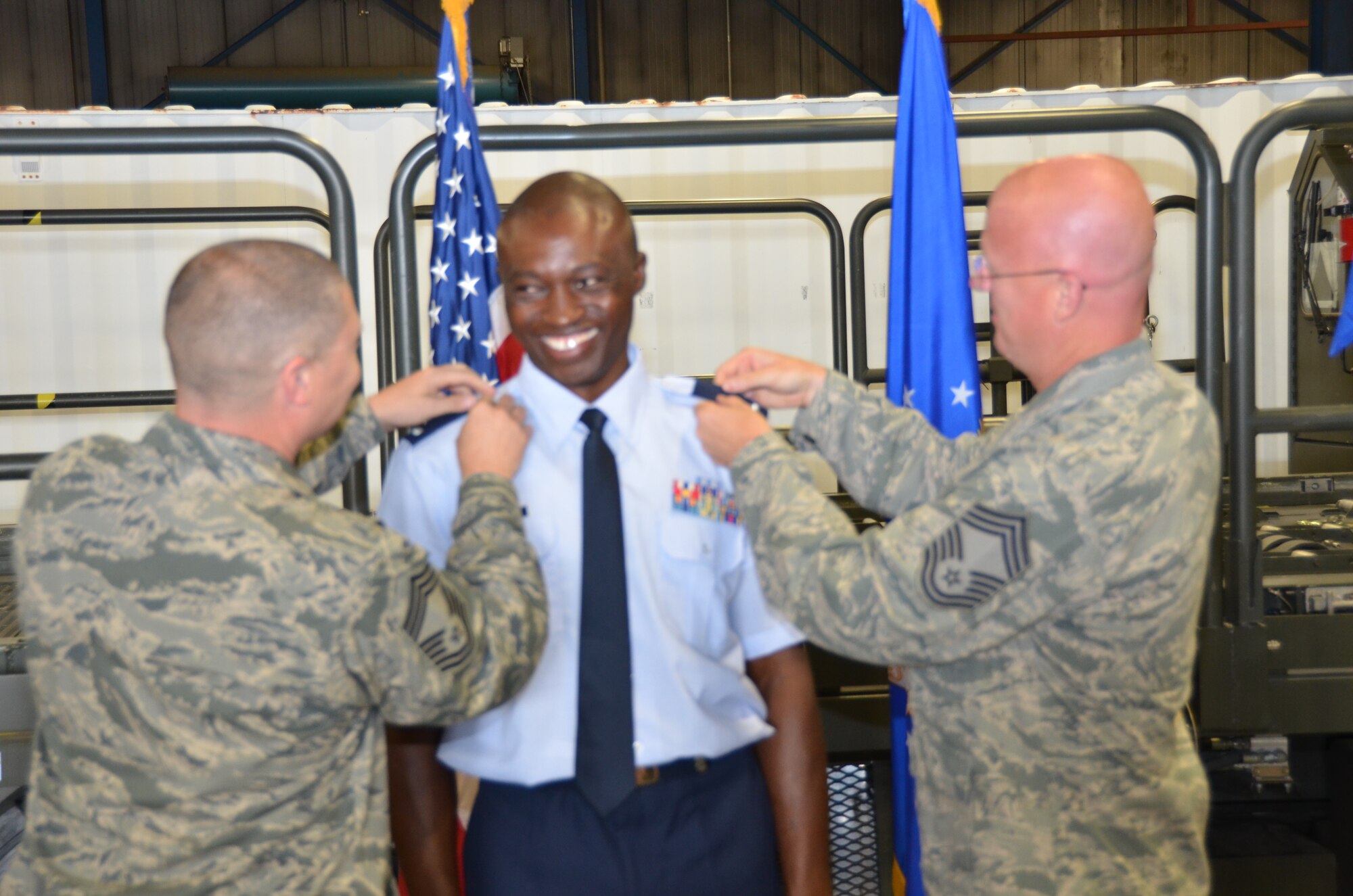 WRIGHT-PATTERSON AIR FORCE BASE, Ohio – Chief Master Sergeants Sean Storms (left) and Robert Haye, both assigned to the 87th Aerial Port, pin second lieutenant rank on Tech. Sgt., now 1st Lt. Will Smith, 87th APS air transportation craftsman, during Smith’s commissioning ceremony May 19. (U.S. Air Force photo/Master Sgt. Charlie Miller)