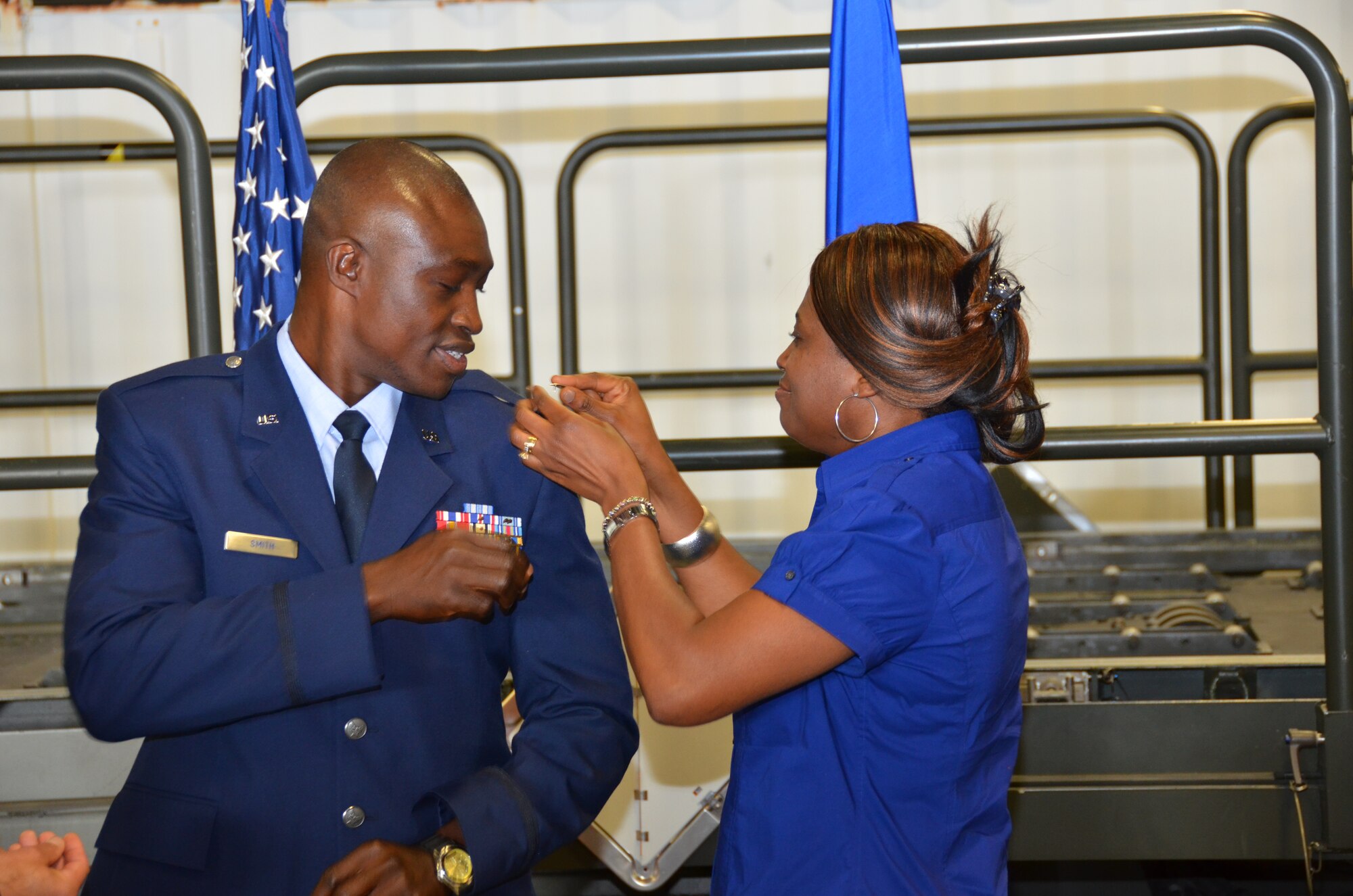 WRIGHT-PATTERSON AIR FORCE BASE, Ohio – Fatmata Smith pins second lieutenant rank on her husband’s Tech. Sgt., now 1st Lt. Will Smith, 87th APS air transportation craftsman, uniform during Smith’s commissioning ceremony May 19. (U.S. Air Force photo/Master Sgt. Charlie Miller)