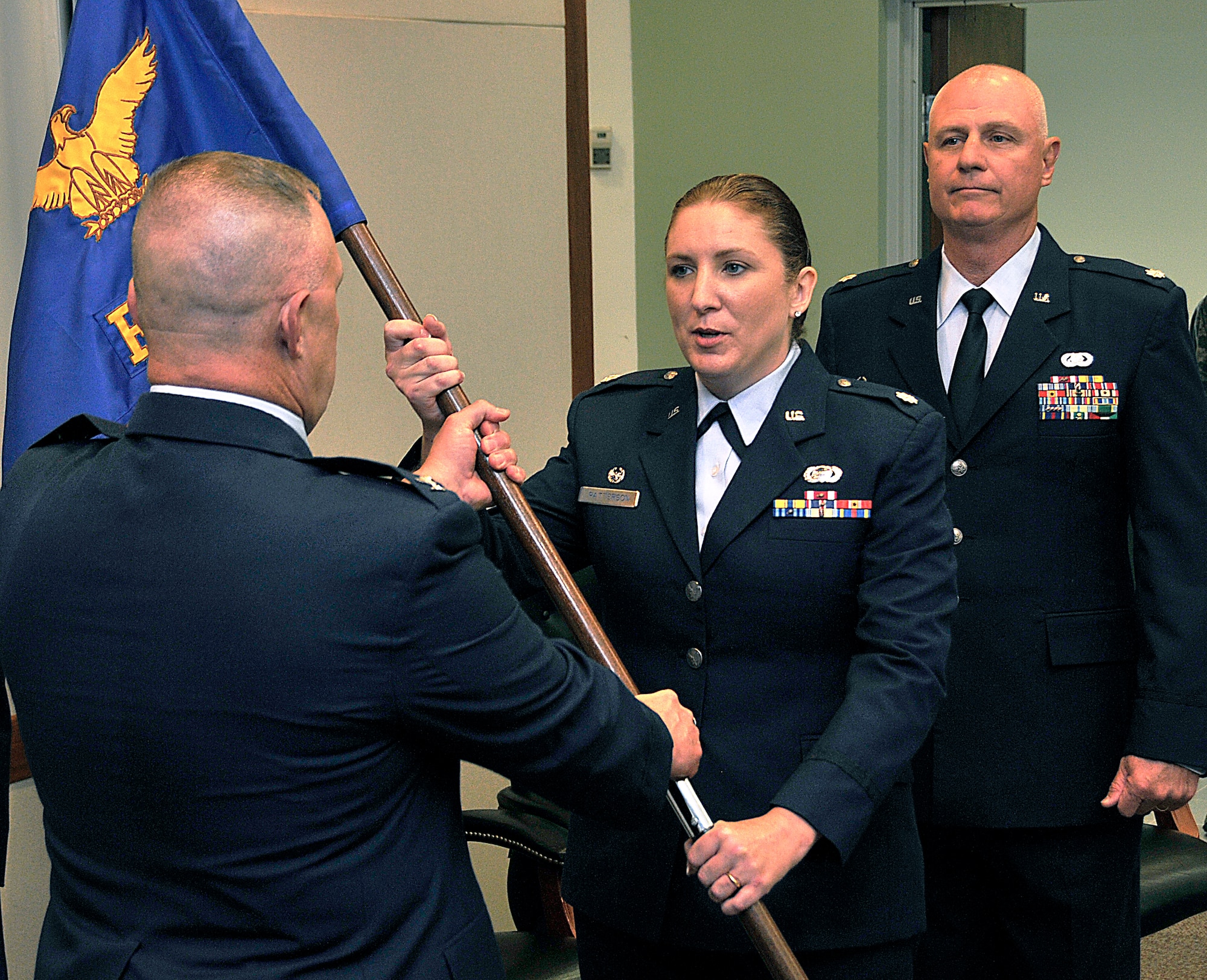 Colonel Elwin Rozyskie, Jr., Commander, 482nd Mission Support Group, handsLt. Col. Norberta J. Patterson the 482nd Force Support Squadron guidon at the unit’s Change of Command Ceremony. Outgoing commander, Lt. Col Lawrence Holbrook looks on. The presenting of the squadron's guidon to a new commander symbolizes the bestowing of responsibility of command. (U. S. Air Force Photo/Staff Sgt. Lou Burton, 482nd Fighter Wing Public Affairs).