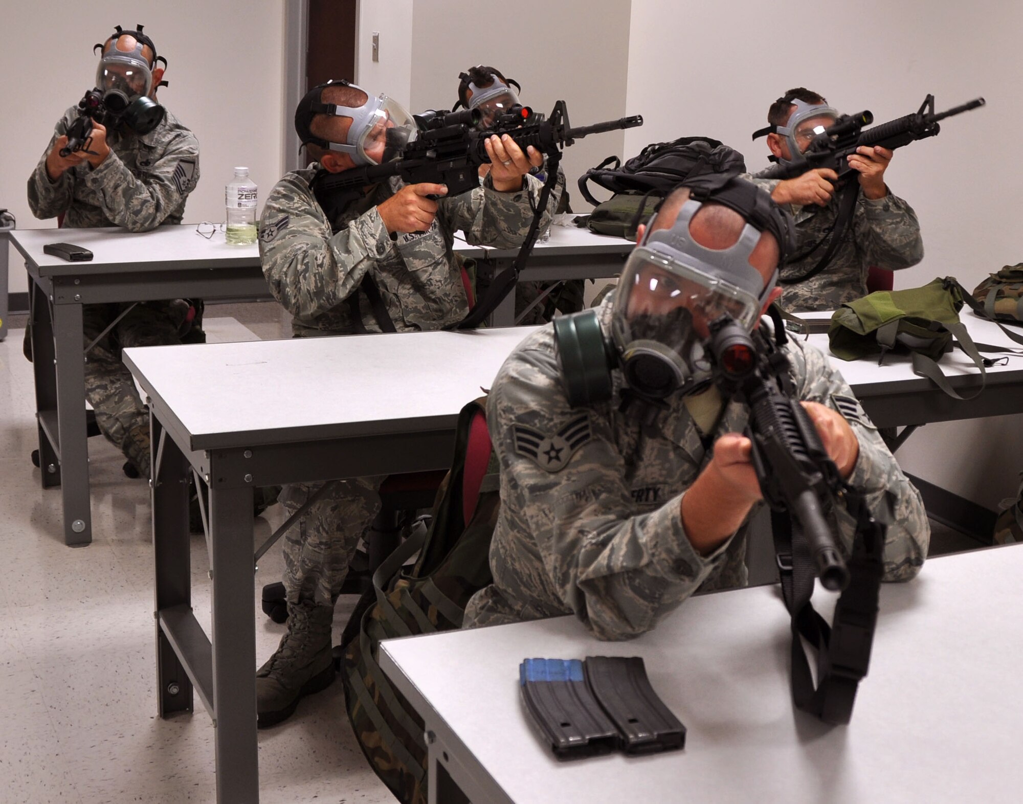 MACDILL AIR FORCE BASE, Fla. – Students of the new Air Force Rifle/Carbine Qualification Course take a moment to adjust their rifles so that they can sight in with gas masks.  The new course focuses on firing while moving, target recognition, and operating in a chemical warfare environment. (Official U.S. Air Force photo/Staff Sgt. Shawn Rhodes)