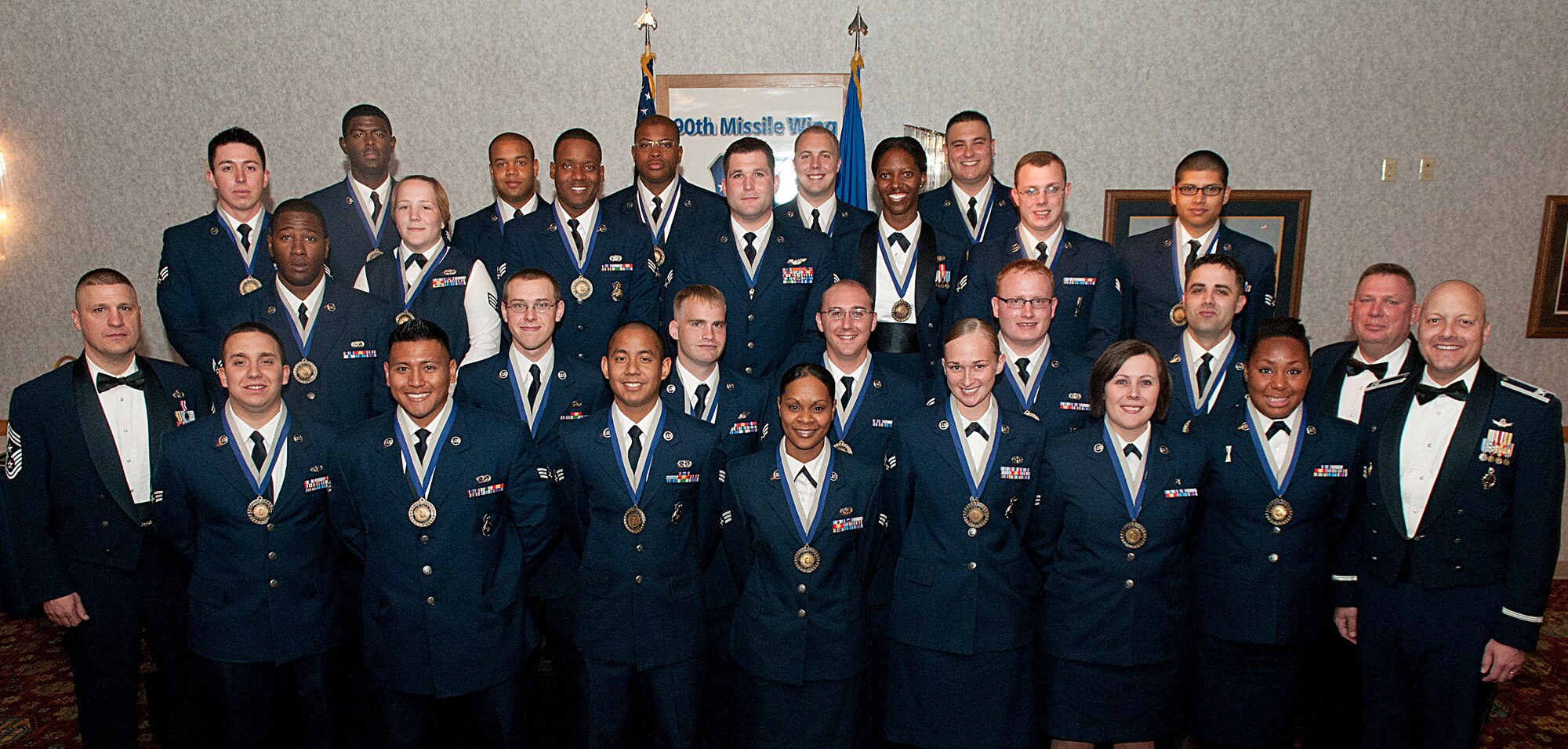 Col. Christopher Coffelt, 90th Missile Wing commander; Chief Master Sgt. Michael Garrou, 90th MW command chief; and Chief Master Sgt. Timothy Ryan, 90th Operations Group chief enlisted manager and the Airman Leadership School graduation guest speaker; pose for a photograph with the graduating ALS class 12-E members in the Trail’s End Club May 17. (U.S. Air Force photo by R.J. Oriez)