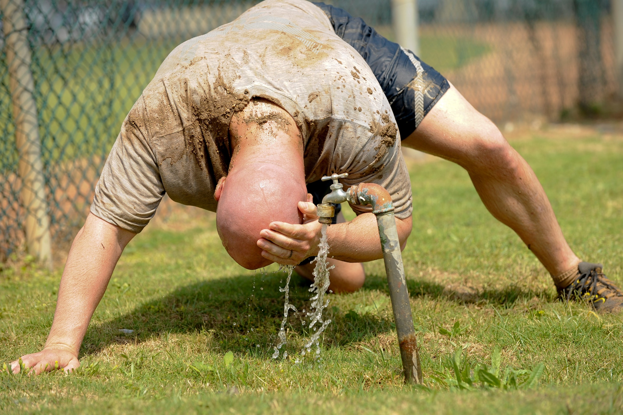 Jason Williams washes the mud off his head after the 39th Air Base Wing Sports Day tug-of-war event June 1, 2012, at Incirlik Air Base, Turkey. Sports day was an event that brought Airmen together through sports and recreation. Airmen from several squadrons competed in friendly games of volleyball, softball, basketball, kickball, dodgeball and tug-of-war. (U.S. Air Force photo by Senior Airman Jarvie Z. Wallace/Released) 

