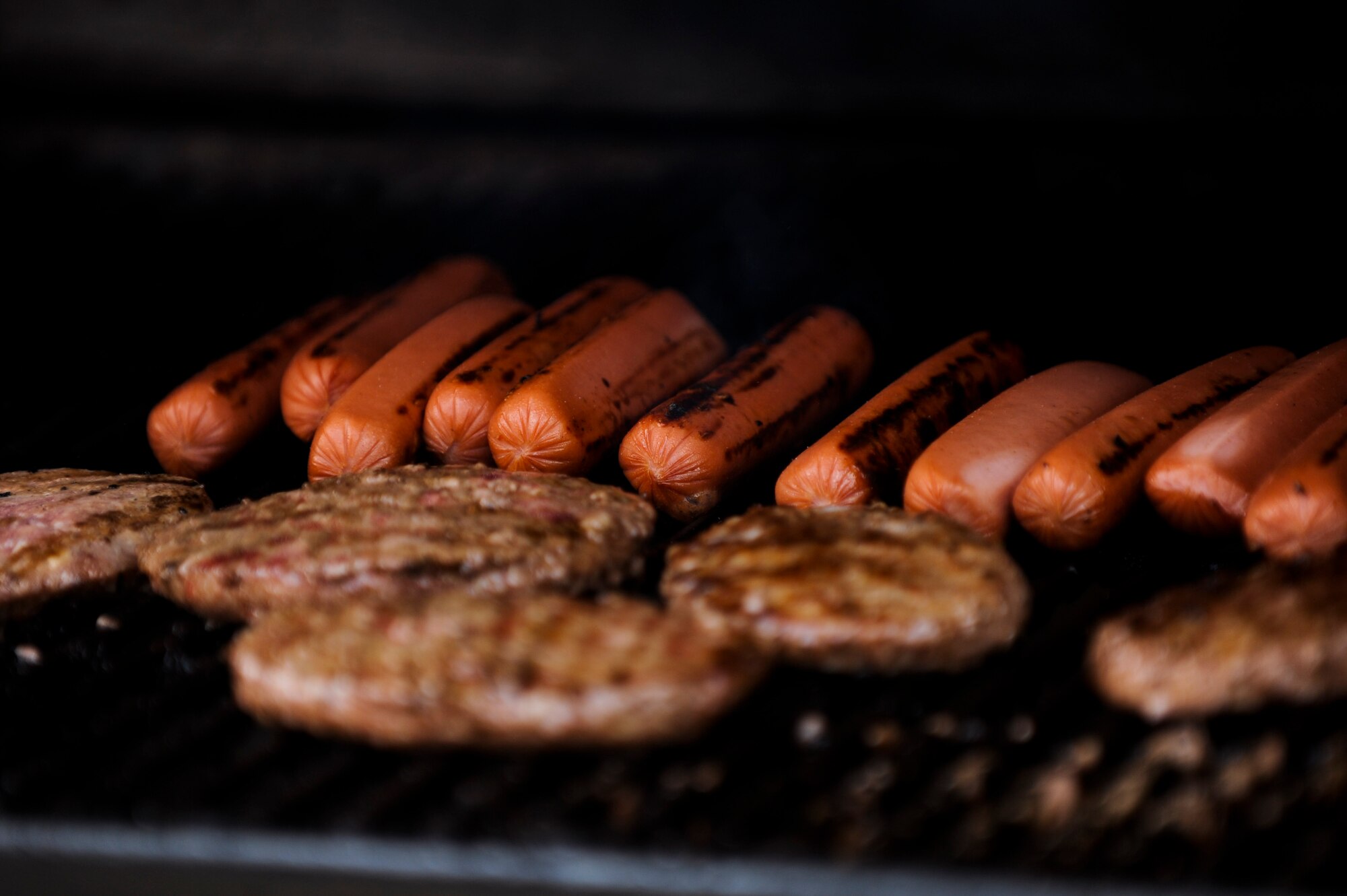 Hot dogs and burgers are prepared during the 39th Air Base Wing Sports Day June 1, 2012, at Incirlik Air Base, Turkey. Sports day was an event that brought Airmen together through sports and recreation. Airmen from several squadrons competed in friendly games of volleyball, softball, basketball, kickball, dodgeball and tug-of-war. (U.S. Air Force photo by Senior Airman Jarvie Z. Wallace/Released) 
