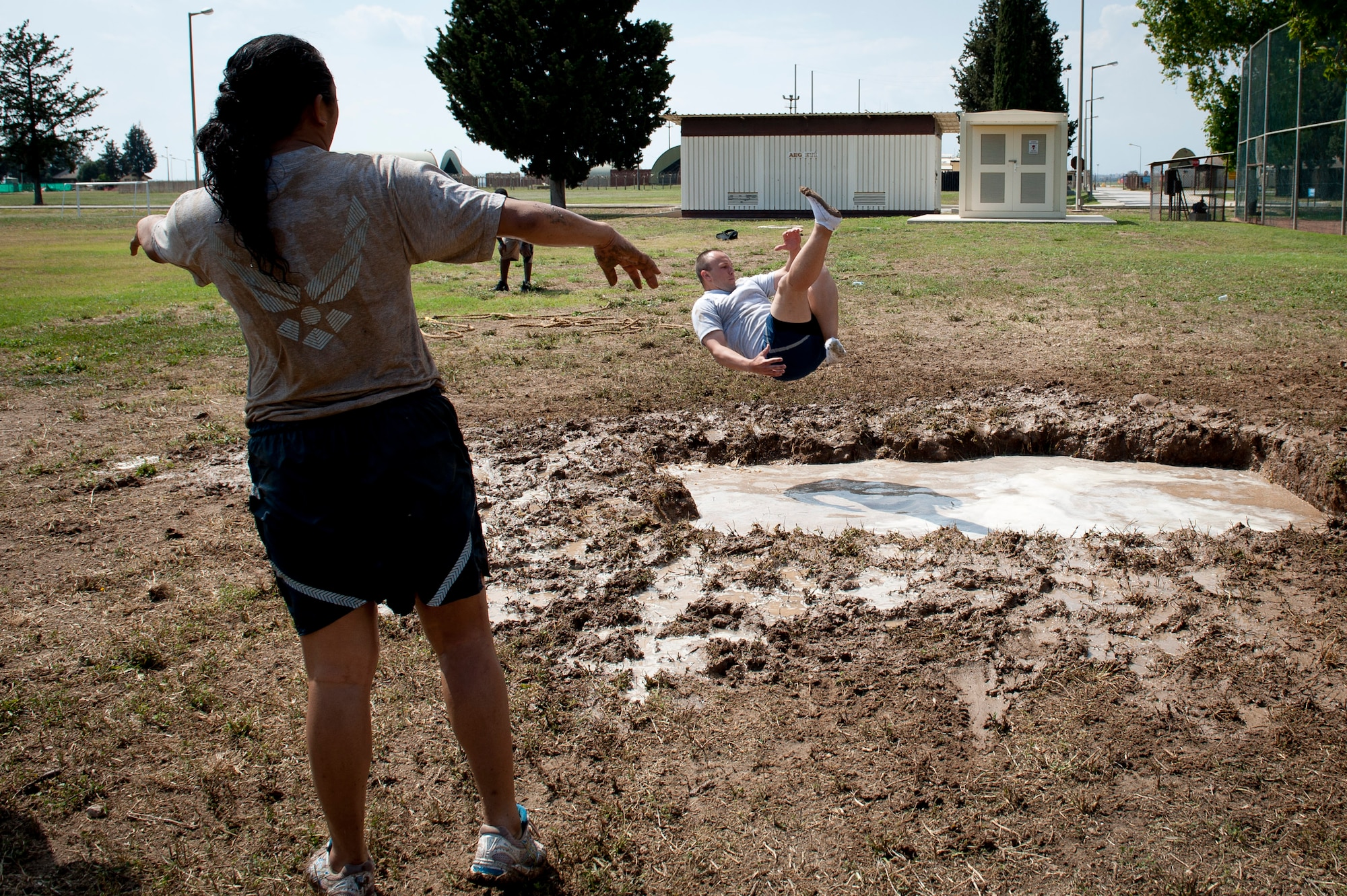 Leonel Halley, 39th Security Forces Squadron, jumps into a three foot mud pit after a victorious game of tug-of-war during the 39th Air Base Wing Sports Day June 1, 2012, at Incirlik Air Base, Turkey. The 39th SFS team was the reigning champion in the tug-of-war event. (U.S. Air Force photo by Senior Airman Anthony Sanchelli/Released)
