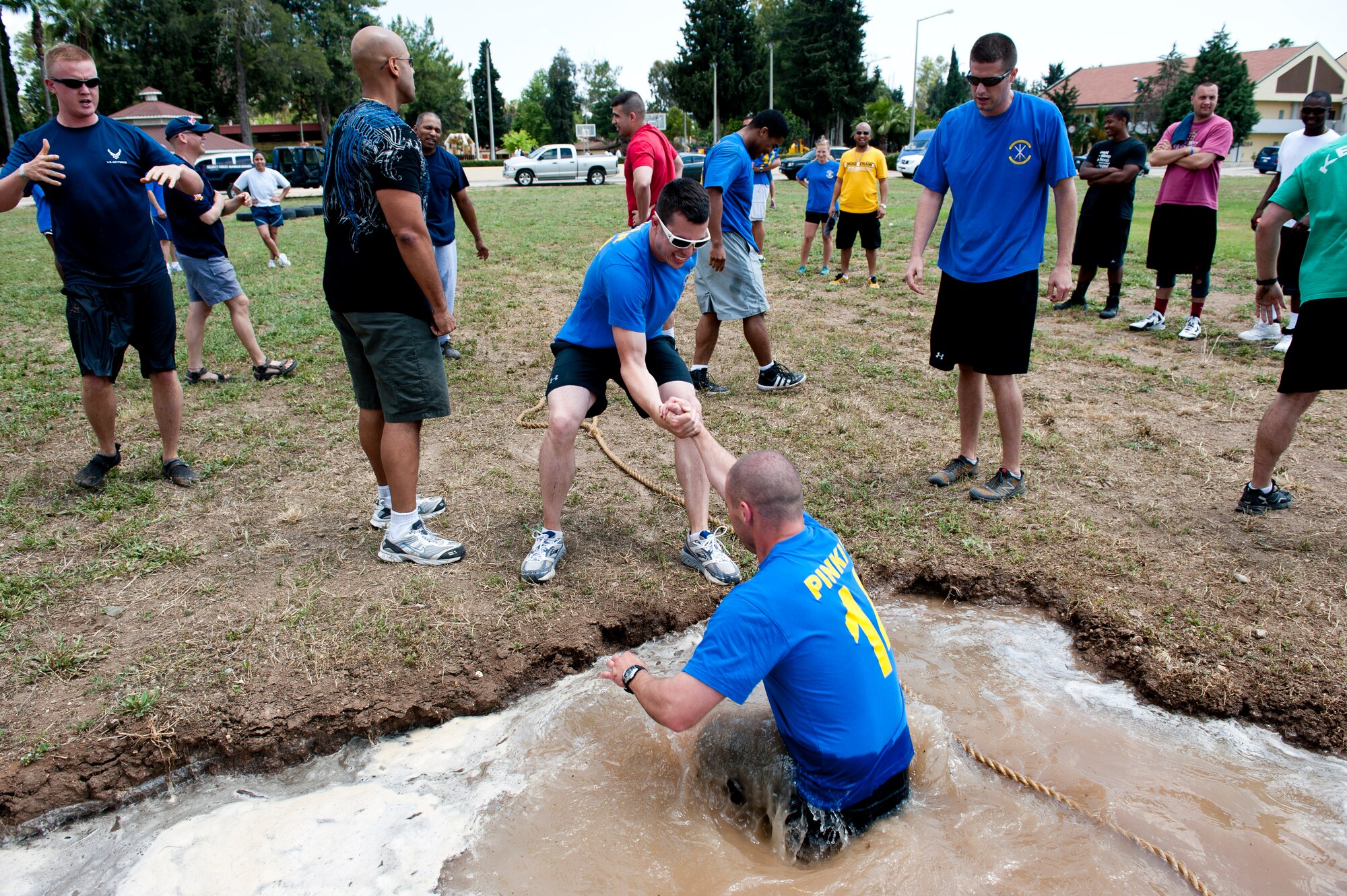 Members of the 39th Contracting Squadron and 39th Force Support Squadron team help one another out of a three foot mud pit after a game of tug-of-war during the 39th Air Base Wing Sports Day June 1, 2012, at Incirlik Air Base, Turkey. Sports day consisted of Incirlik Airmen competing in 13 different sporting events ranging from dodgeball and kickball to bowling and golf. (U.S. Air Force photo by Senior Airman Anthony Sanchelli/Released)
