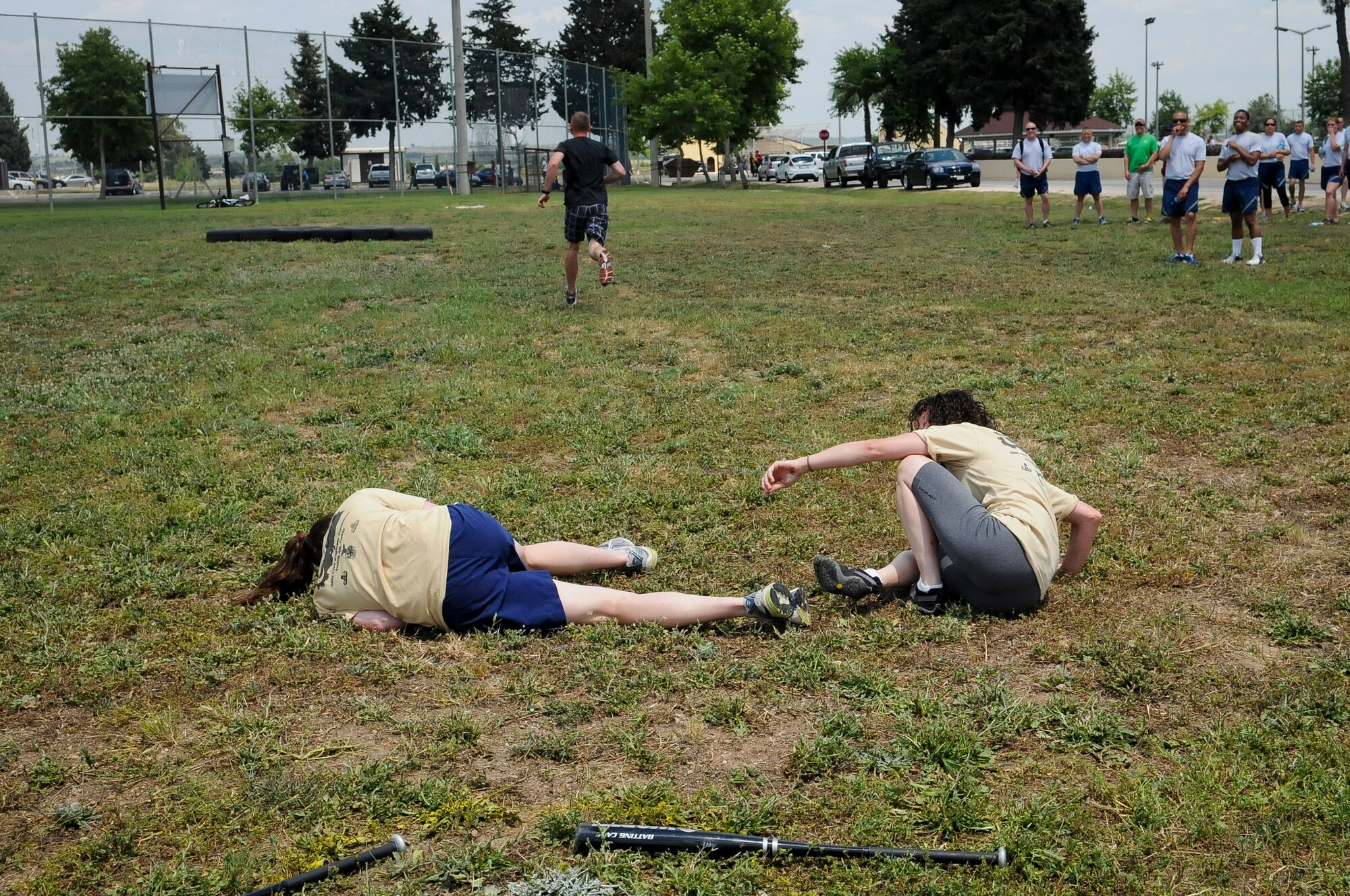 Tina Hernandez and Kathryn Marron, both from the 39th Civil Engineer Squadron, recover from a fall after completing the dizzy bat section of an obstacle course during the 39th Air Base Wing Sports Day June 1, 2012 at Incirlik Air Base, Turkey. Sports day was designed to build teamwork and camaraderie among different work sections by competing in various sporting events for the commander's trophy. (U.S. Air Force photo by Senior Airman Marissa Tucker/Released)
