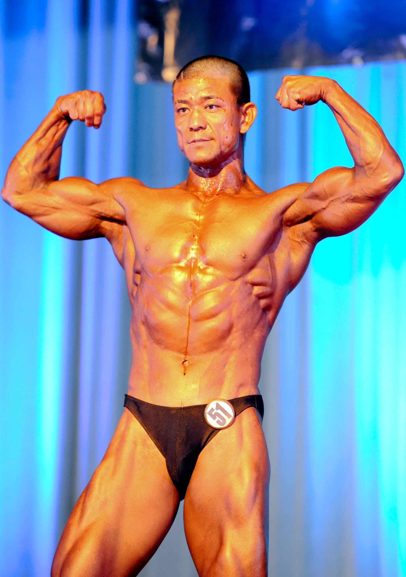Tomoya Nakadomari flexes his muscles after winning the Overall Male Award during the 6th Annual Pacific Muscle Classic on Kadena Air Base, Japan, June 3, 2012. The Overall Male Award is given to the one who best displays showmanship, as well as their fitness and figures. (U.S. Air Force photo/Airman 1st Class Justin Veazie)
