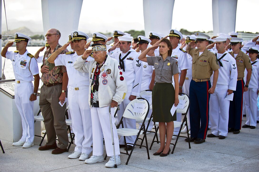 World War II veterans, civilian guests, sailors, Marines and airmen salute during the playing of the national anthem at the USS Arizona Memorial in Pearl Harbor, Honolulu, June 4, 2012, during a wreath-laying ceremony to commemorate the 70th anniversary of the Battle of Midway.