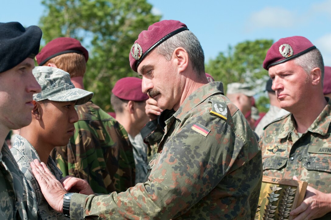 Paratroopers exchange German jump wings at La Fiere drop zone after completing an airborne operation commemorating the D-Day and WWII events in Sainte-Mere-Eglise, France, June 3, 2012. Task Force 68, which is made up of paratroopers from U.S., Germany, France, Holland, and United Kingdom, re-enacted the D-Day airborne operation on the La Fiere fields near Sainte-Mere-Eglise.
