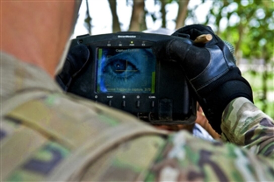 A U.S. paratrooper uses a handheld identity detection device to scan an Afghan's iris while on patrol in a village near Forward Operating Base Arian in Afghanistan's Ghazni province, May 29, 2012. The soldier is assigned to the 82nd Airborne Division's 2nd Battalion, 504th Parachute Infantry Regiment, 1st Brigade Combat Team.