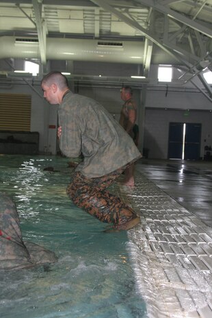 A recruit of Company G, 2nd Recruit Training Battalion, jumps into the water before swimming 25 meters across the pool May 22 at the swim tank aboard Marine Corps Recruit Depot San Diego. Recruits learn the importance of combat water survival in recruit training because the probability of them being stationed in aquatic environments is high.