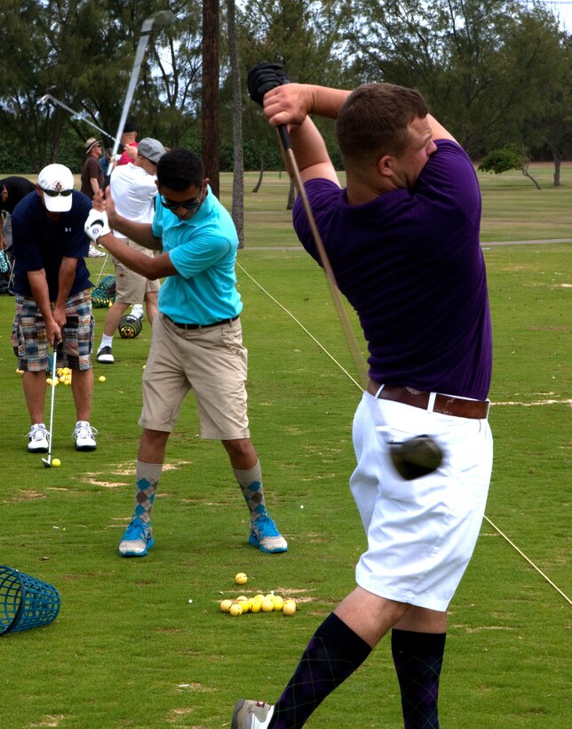 MARINE CORPS BASE, Hawaii – Private Matt M. Leonard (right) and Lance Cpl. George A. Reynoso, both vehicle operators for the motor transportation section, Headquarters and Service Battalion, U.S. Marine Corps Forces, Pacific, warm up at the driving range before teeing off in the 4th Annual MarForPac Golf Tournament at Kaneohe Klipper Golf Course here, June 1. Some of the proceeds from the tournament will go toward offsetting the cost of tickets for junior service members at MarForPac’s Marine Corps birthday ball in November.