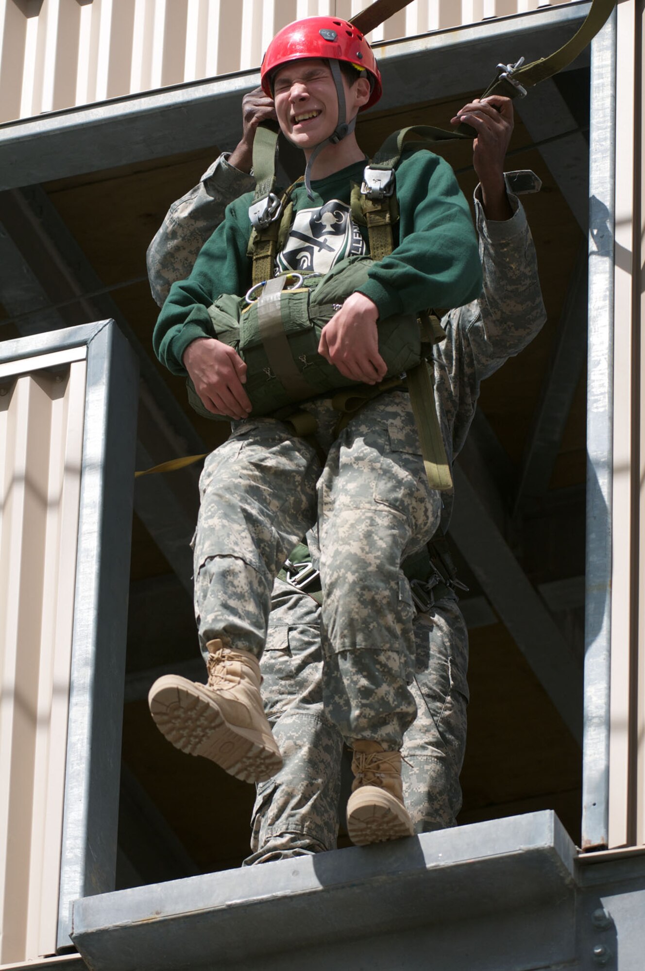 JOINT BASE ELMENDORF-RICHARDSON, Alaska -- With the help of Sgt. 1st Class Donshay Morning, 6th Engineer Battalion, Colony High School Junior ROTC Cadet James Sawyer, 17, exits the 34-foot jump tower June 1 at the Airborne Sustainment Training Area. (U.S. Air Force photo/David Bedard)