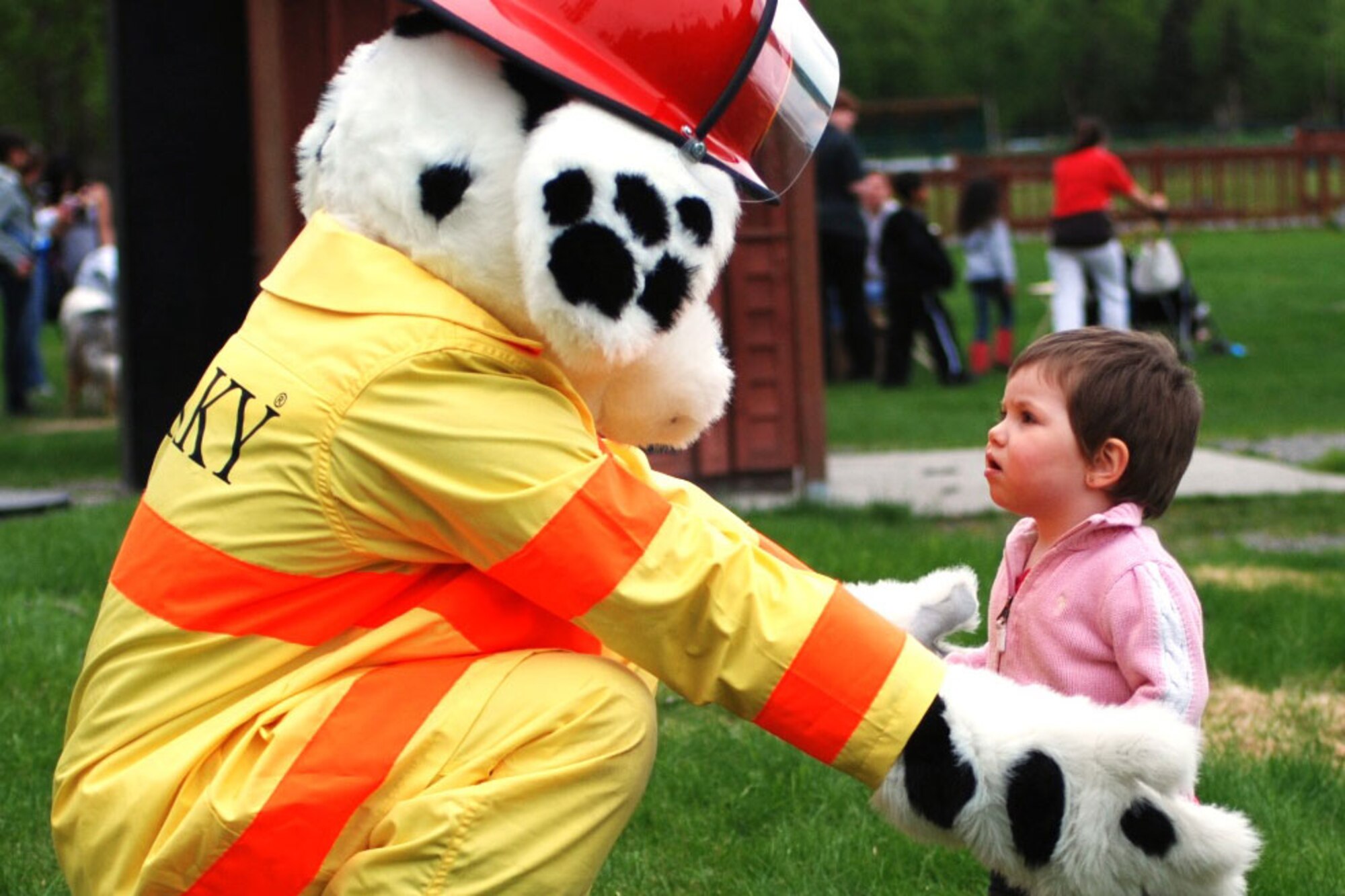 Sparky the Firehouse Dalmatian offers a hug to a cautious toddler during the 4th
Airborne Brigade Combat Team, 25th Infantry Division mid-tour celebration at Cottonwood Park on May 31. (U.S. Army photo/Staff Sgt. Matthew E. Winstead)