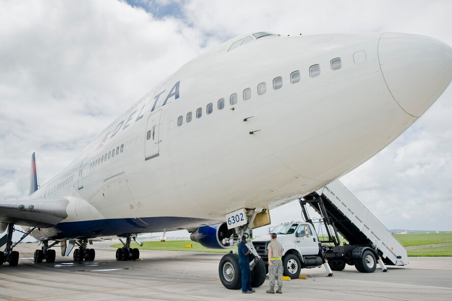 Staff Sgt. Samuel Owens and Staff Sgt. Kenneth Massey, 733rd Air Mobility Squadron, provide ground services for the Delta Boeing 747 on Kadena Air Base, Japan, June 6, 2012. The Boeing 747 was diverted to Kadena due to an onboard medical emergency. Kadena’s Airmen help provide services like maintenance, refueling and other ground services. Last month, Kadena Airmen assisted two civilian aircraft originally bound for Naha. Kadena is a divert location for Naha airfield and is occasionally used when weather or other situations prevent aircraft from landing at Naha. (U.S. Air Force Photo/Staff Sgt. Jonathan Steffen)
