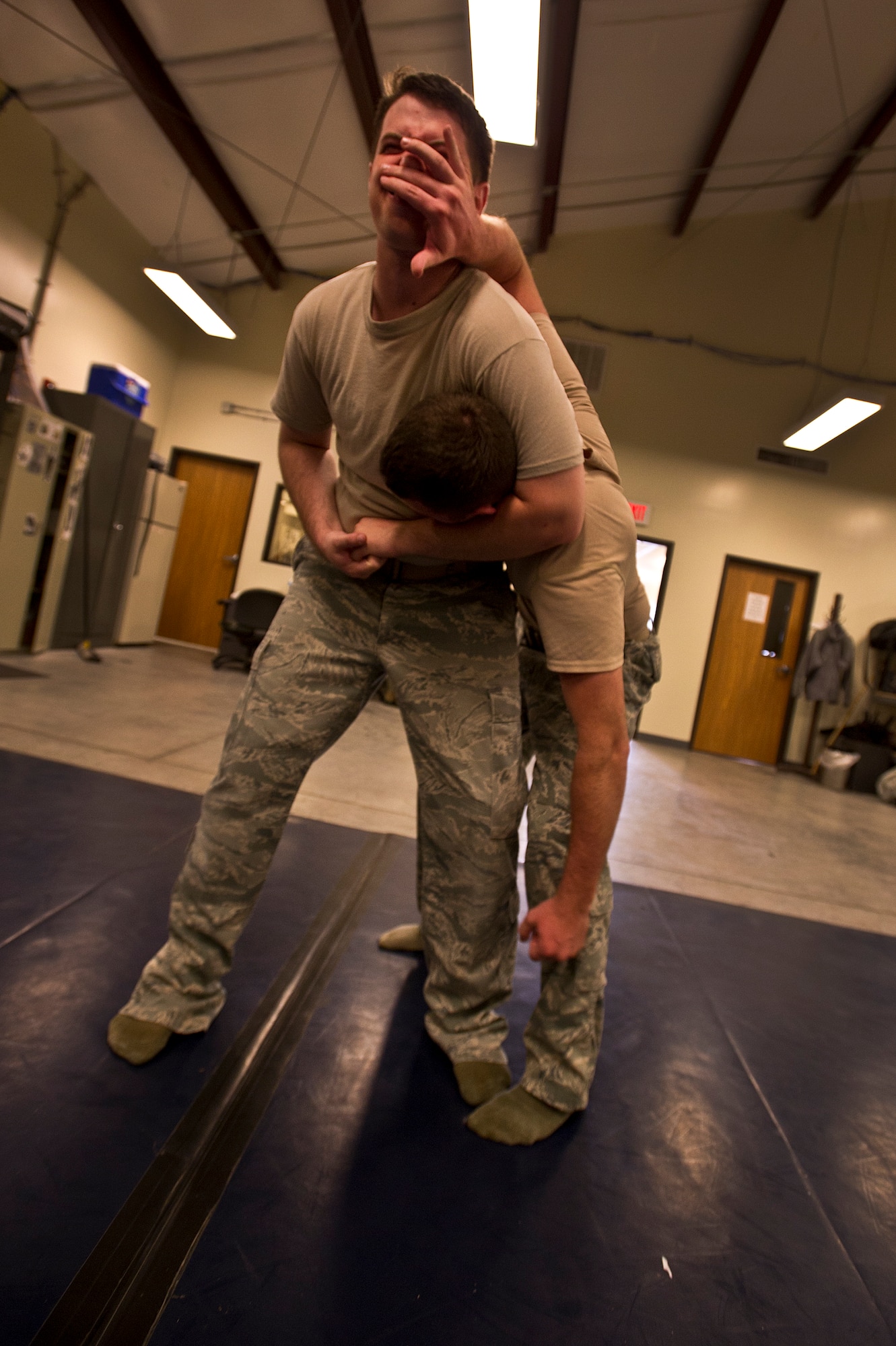 Senior Airman Stephen Strickland and Senior Airman Curtis March, 628th Security Forces Squadron patrolmen, grapple each other during Personal Apprehension Restraint Techniques and Mechanical Advantage Control Hold training at the combat arms building on Joint Base Charleston - Air Base, S.C., June 5, 2012. The training is an annual requirement for the Airmen in case of a physical situation while on duty. (U.S. Air Force photo by Airman 1st Class George Goslin)