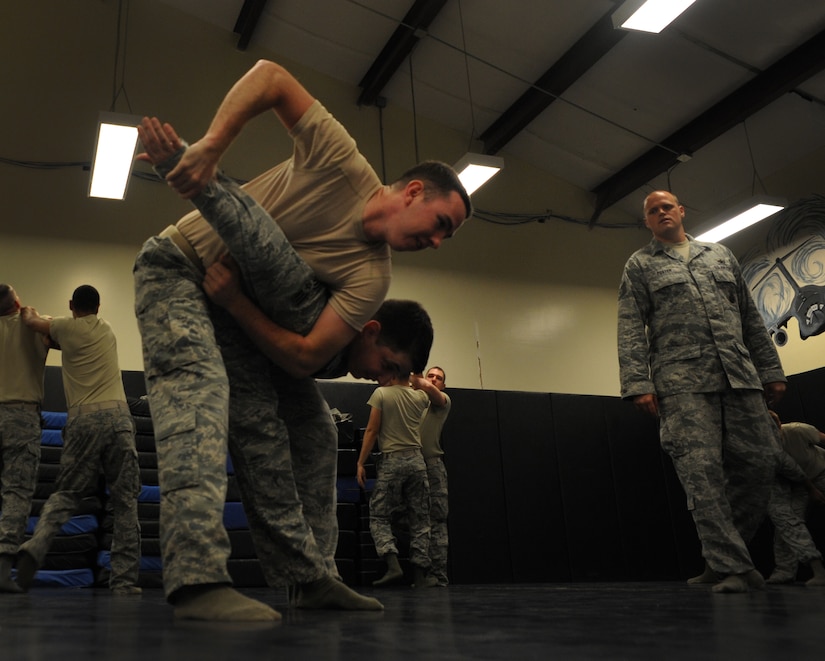 Senior Airmen Stephen Strickland and Senior Airman Curtis March, 628th Security Forces Squadron, practice restraint techniques as Tech. Sgt. John Foster, also 628th SFS, inspects June 5, 2012 at Joint Base Charleston, S.C. Security Forces practice weapon retention, physical apprehension and restraint techniques as an annual training requirement. (U.S. Air Force photo/Airman 1st Class Ashlee Galloway)