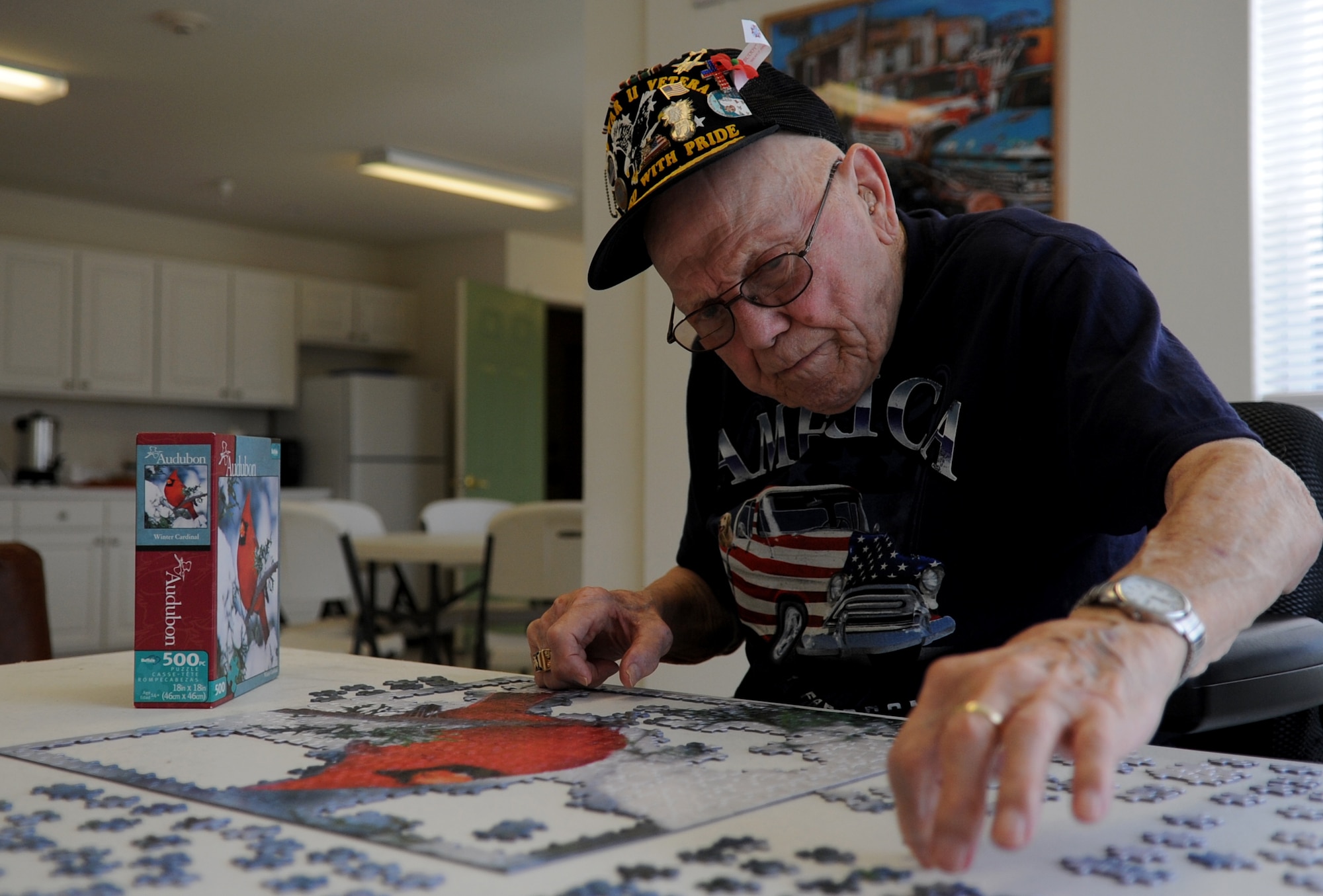 John Coons, a former U.S. Army private first class and World War II veteran, puts together a jigsaw puzzle at the community center near his Hampton, Va. home, June 6, 2012. The puzzles offer Coons a mental reprieve from the post-traumatic stress disorder symptoms he still experiences from his time as a Soldier. (U.S. Air Force photo by Senior Airman Jarad A. Denton/Released)