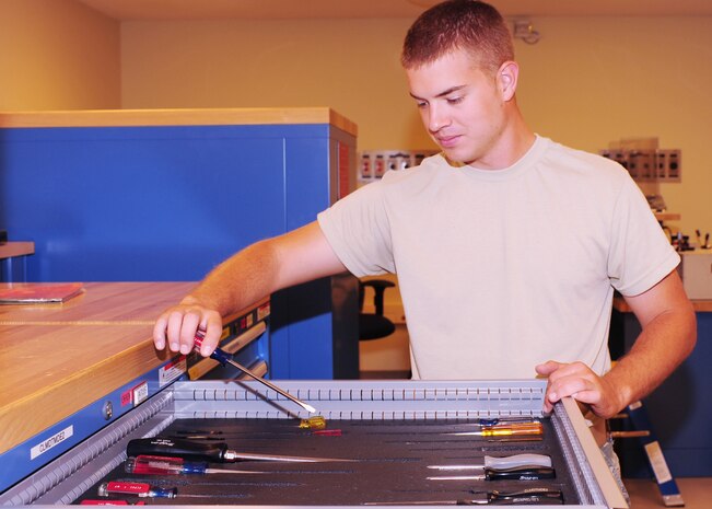 Airman 1st Class Herschell Miller, 437th Maintenance Squadron Precision Measurement Equipment Laboratory technician out of Joint Base Charleston, S.C., grabs a tool, May 29, 2012. The PMEL makes sure planes fly to engineer specifications. (U.S. Air Force photo/ Airman 1st Class Chacarra Walker)