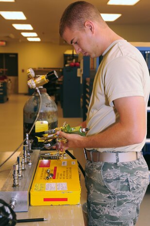 Airman 1st Class Herschell Miller, 437th Maintenance Squadron Precision Measurement Equipment Laboratory technician out of Joint Base Charleston, S.C., calibrates a tire-inflator kit, May 29, 2012. The tire-inflator kit is used to inflate aircraft tires.(U.S. Air Force photo/ Airman 1st Class Chacarra Walker)