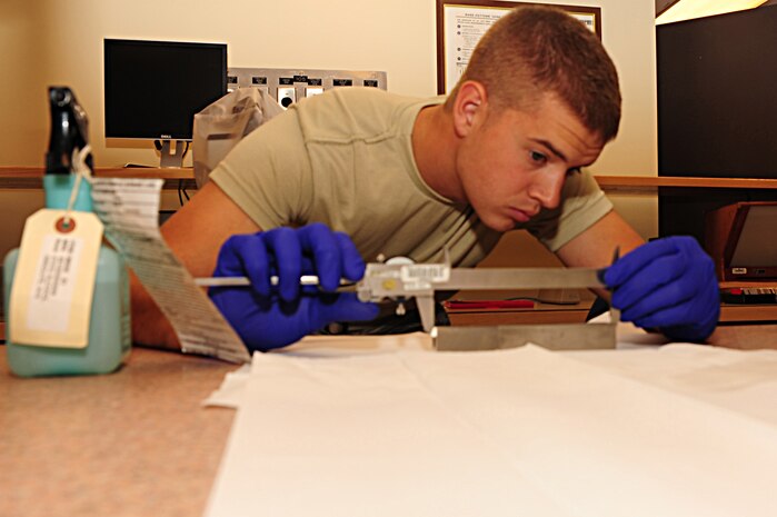 Airman 1st Class Herschell Miller, 437th Maintenance Squadron Precision Measurement Equipment Laboratory technician out of Joint Base Charleston, S.C., calibrates a dial caliper, May 29, 2012.  PMEL Airmen perform and manage repair, calibration of test, measurement, and diagnostic equipment.  (U.S. Air Force photo/ Airman 1st Class Chacarra Walker)