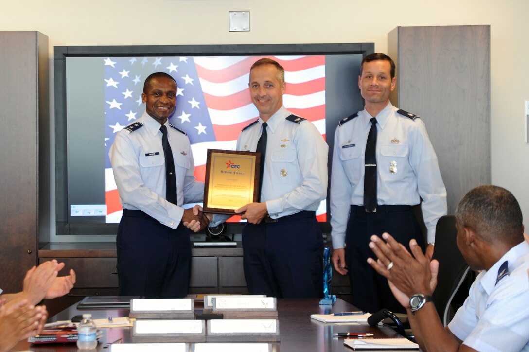 Air Force District of Washington Commander Maj. Gen. Darren W. McDew presents 844th Communication Group Commander Col. Anthony Thomas a merit award June 6 on Joint Base Andrews, Md., in recognition of the 2012 Combined Federal Campaign. (U.S. Air Force photo by Airman 1st Class Tabitha N. Haynes)