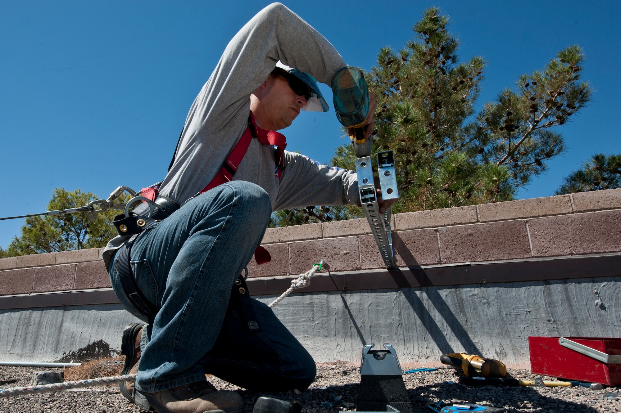 Mike Dietrich, a Bombard Electric Wireman Apprentice, installs a mount for solar panels June 6, 2012, at Nellis Air Force Base, Nev. The solar panels are scheduled to be completed within the next two weeks. (U.S. Air Force photo by Airman 1st Class Jason Couillard)