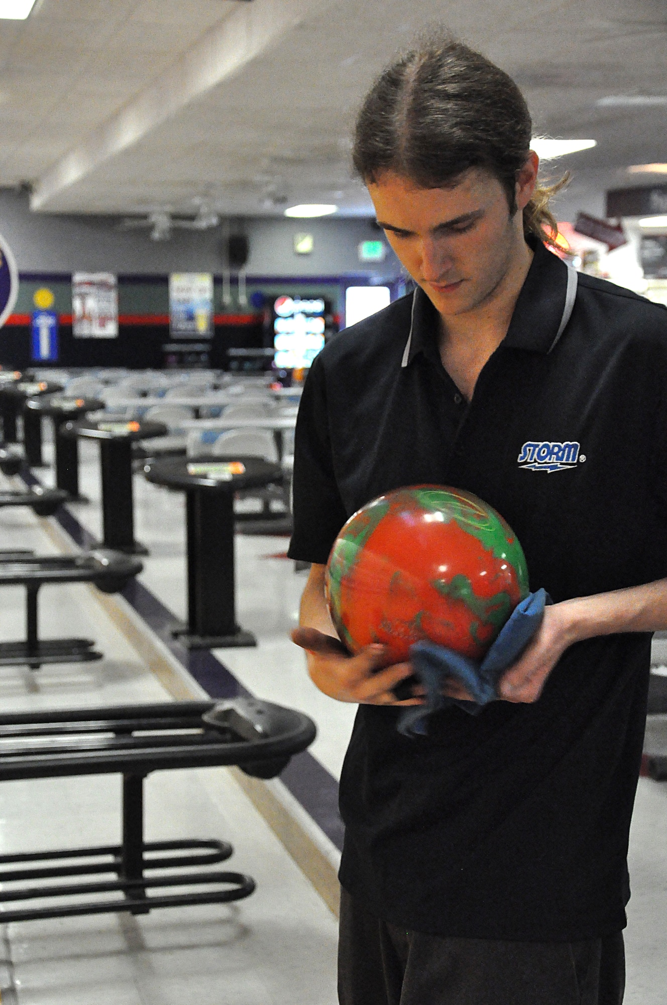 Davin McIntire wipes down his ball to ensure proper spin at the Stars and Strikes Bowling Center May 29.  McIntire recently bowled his second perfect 300 score.(U.S. Air Force photo/Airman 1st Class Jake Eckhardt)

