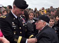 Army Maj. Gen. James McConville places an Airborne pin upon the chest of World War II veteran Al Mambre June 6, 2012, after a ceremony that unveiled a statue near Utah Beach, France. Mambre, a member of the famed “Easy” Company, 2nd Battalion, 506th Parachute Infantry Regiment of the 101st Airborne Division, was joined by other World War II veterans and more than 200 attendees to unveil a statue dedicated to Army Maj. Richard “Dick” Winters. The memorial eulogizes Winter’s unwavering commitment to the soldiers he was assigned and the leadership young officers and noncommissioned officers showcased during battle in Europe. Winters and his company were made famous by the New York Times bestseller and same-titled television series “Band of Brothers” that documents the Airborne paratroopers’ time fighting in France, Holland and Germany. McConville is the commanding general of the 101st Airborne Division. (U.S. Air Force photo/Staff Sgt. Stephen J. Collier)