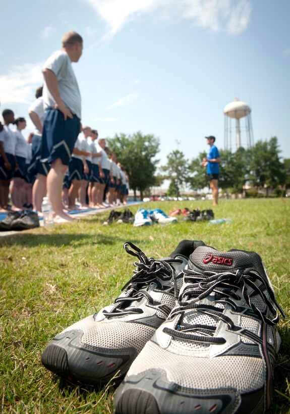 A pair of discarded shoes sits as Airmen line up to practice running drills and newly learned techniques during a running clinic at Moody Air Force Base, Ga., May 30, 2012. Airmen were encouraged to take their shoes off, which forces a mid-foot strike instead of a heel strike. (U.S. Air Force photo by Airman 1st Class Jarrod Grammel/Released)
