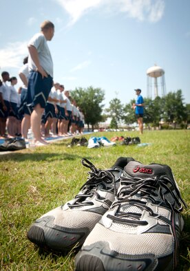 A pair of discarded shoes sits as Airmen line up to practice running drills and newly learned techniques during a running clinic at Moody Air Force Base, Ga., May 30, 2012. Airmen were encouraged to take their shoes off, which forces a mid-foot strike instead of a heel strike. (U.S. Air Force photo by Airman 1st Class Jarrod Grammel/Released)
