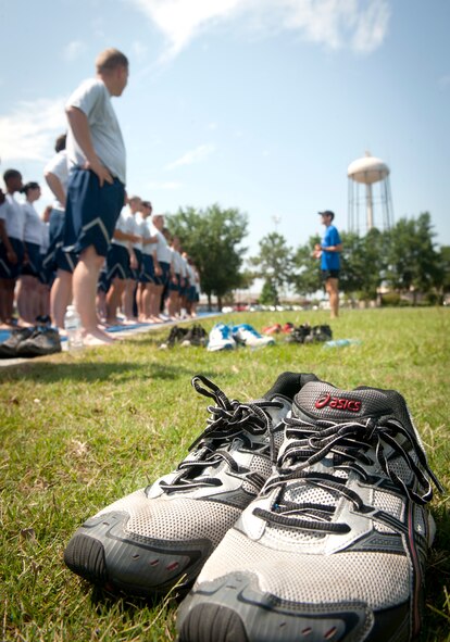 A pair of discarded shoes sits as Airmen line up to practice running drills and newly learned techniques during a running clinic at Moody Air Force Base, Ga., May 30, 2012. Airmen were encouraged to take their shoes off, which forces a mid-foot strike instead of a heel strike. (U.S. Air Force photo by Airman 1st Class Jarrod Grammel/Released)

