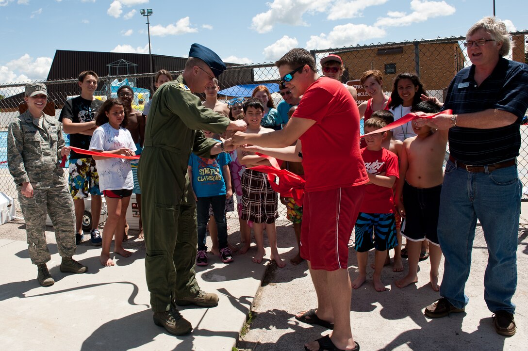 Col. Mark Weatherington, 28th Bomb Wing commander, Austin Sukut, 28th Force Support Squadron outdoor recreation lifeguard, along with other members of the Ellsworth community participate in the grand opening of the outdoor pool on Ellsworth Air Force Base, S.D., June 1, 2012. The outdoor pool is open from noon to 6 p.m. every day through Labor Day, weather permitting. For more information, call the Outdoor Recreation office at (605) 385-2999. (U.S. Air Force photo by Airman 1st Class Kate Thornton/Released)