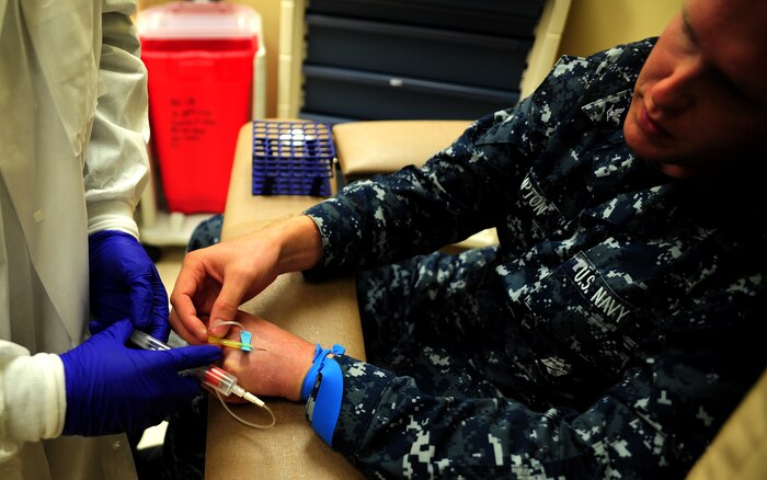 Petty Officer 3rd Class Matthew Hampton, a hospital corpsman with the Naval Health Clinic at Joint Base Charleston – Weapons Station, S.C., takes one for the team as he gets his blood drawn by Seaman Jonathan Torres, a hospital corpsman with the Naval Health Clinic at JB Charleston – Weapons Station, S.C., during a routine training exercise June 1, 2012. Torres, originally assigned to the family practice office at the clinic, is training in the laboratory. Hampton is training Torres on how to properly draw blood from patients at the phlebotomy lab. (U.S. Air Force photo / Airman 1st Class Tom Brading)