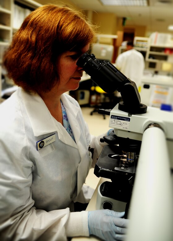 Lea Shoup, a medical lab technician with the Naval Health Clinic at Joint Base Charleston – Weapons Station, S.C., reviews liquid specimens underneath a medical microscope in the Hematology Laboratory June 1, 2012. Shoup is a seven-year veteran of the Hematology Laboratory. The medical microscopes have an additional microscope attached for training purposes, and they’re able to detect various items, depending on the liquid being magnified, within the specimen. (U.S. Air Force photo / Airman 1st Class Tom Brading) 