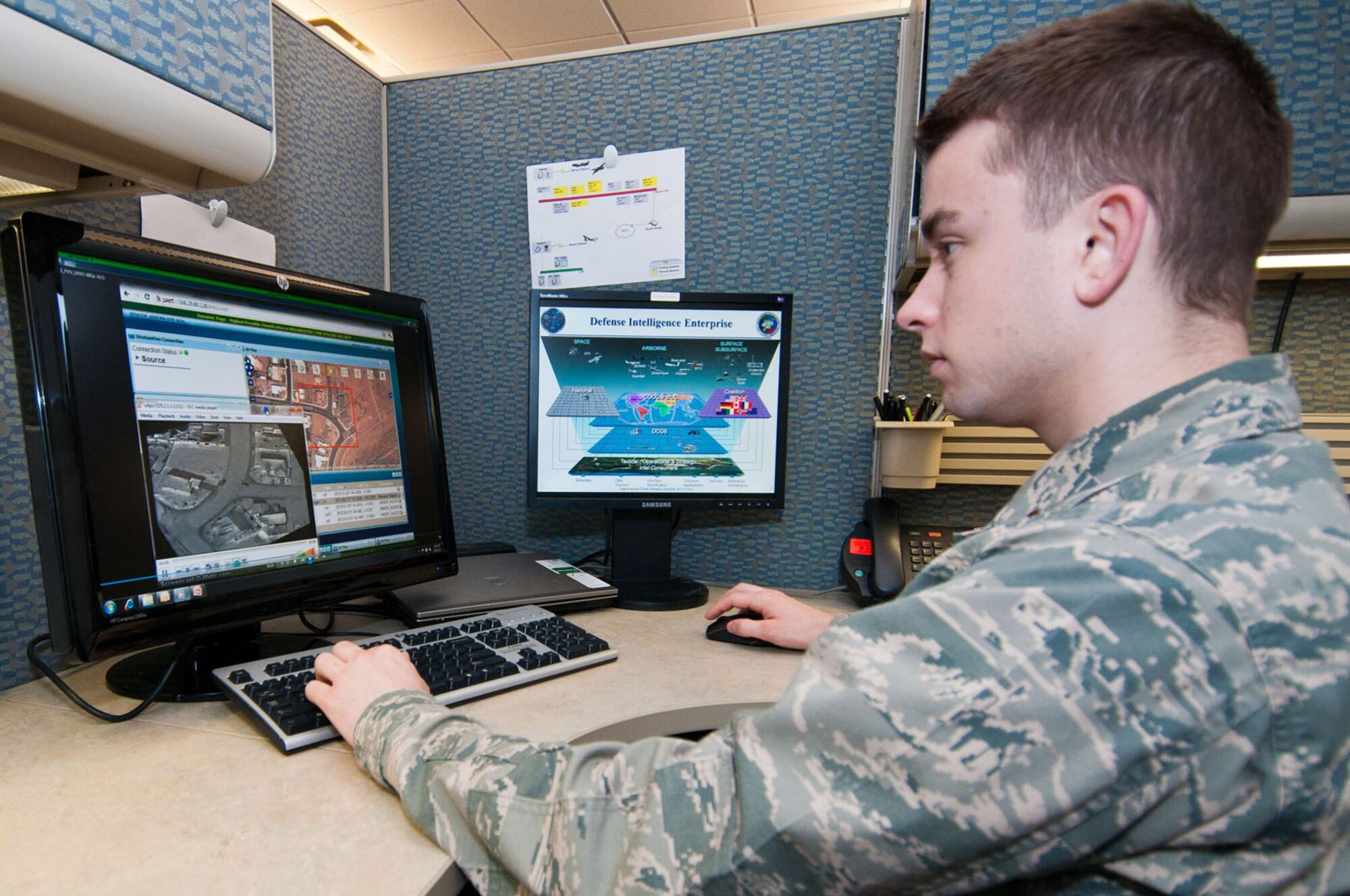 HANSCOM AIR FORCE BASE, Mass. - 2nd Lt. Spencer Edwards, Distributed Common Ground/Surface System Exercise Technical Working Group lead, reviews a demonstration of data from the DCGS Integration Backbone June 6. The Electronic Systems Center recently awarded contracts to improve the data discovery and retrieval capabilities of the DIB. (U.S. Air Force photo by Rick Berry)