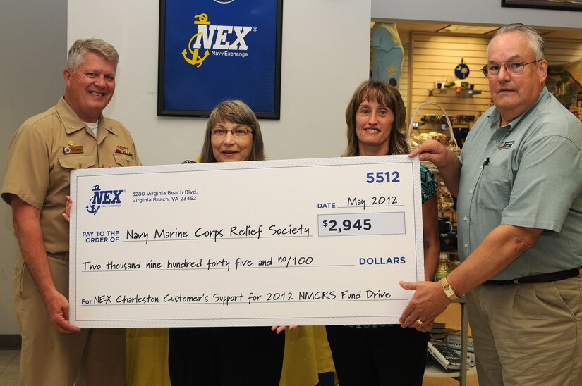 Captain Thomas Bailey, Joint Base Charleston deputy commander, presents a check to David Hastings, Navy Marine Corps Relief Society director. The check came from the proceeds of Naval Exchange Customer Support’s fund drive for the 2012 Navy Marine Corps Relief Society at the NEX at JB Charleston – Weapons Station, June 1. The exchange’s top sellers for the fund drive were Mary Helen White and Christine Reyes. Christine Finkler, not pictured, was also a top seller. (U.S. Navy photo/Petty Officer 1st Class Jennifer Hudson)