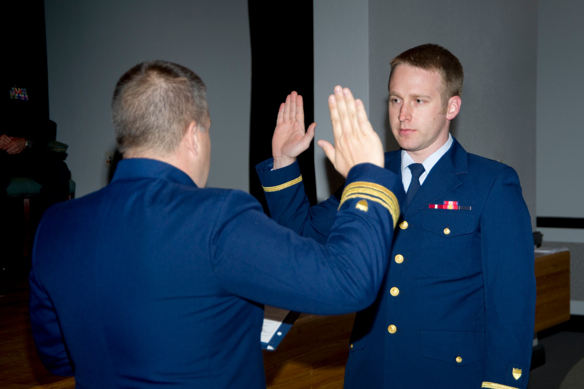 Coast Guard Lt. Cmdr. Jonathan Stehn administered the oath of office to Coast Guard Ensign Seth Harris, 81st Medical Operations Squadron, after receiving his physician assistants diploma May 10, 2012, at the Keesler Hospital's Don Wylie Auditorium at Keesler Air Force Base, Miss. (U.S. Air Force photo by Adam Bond)