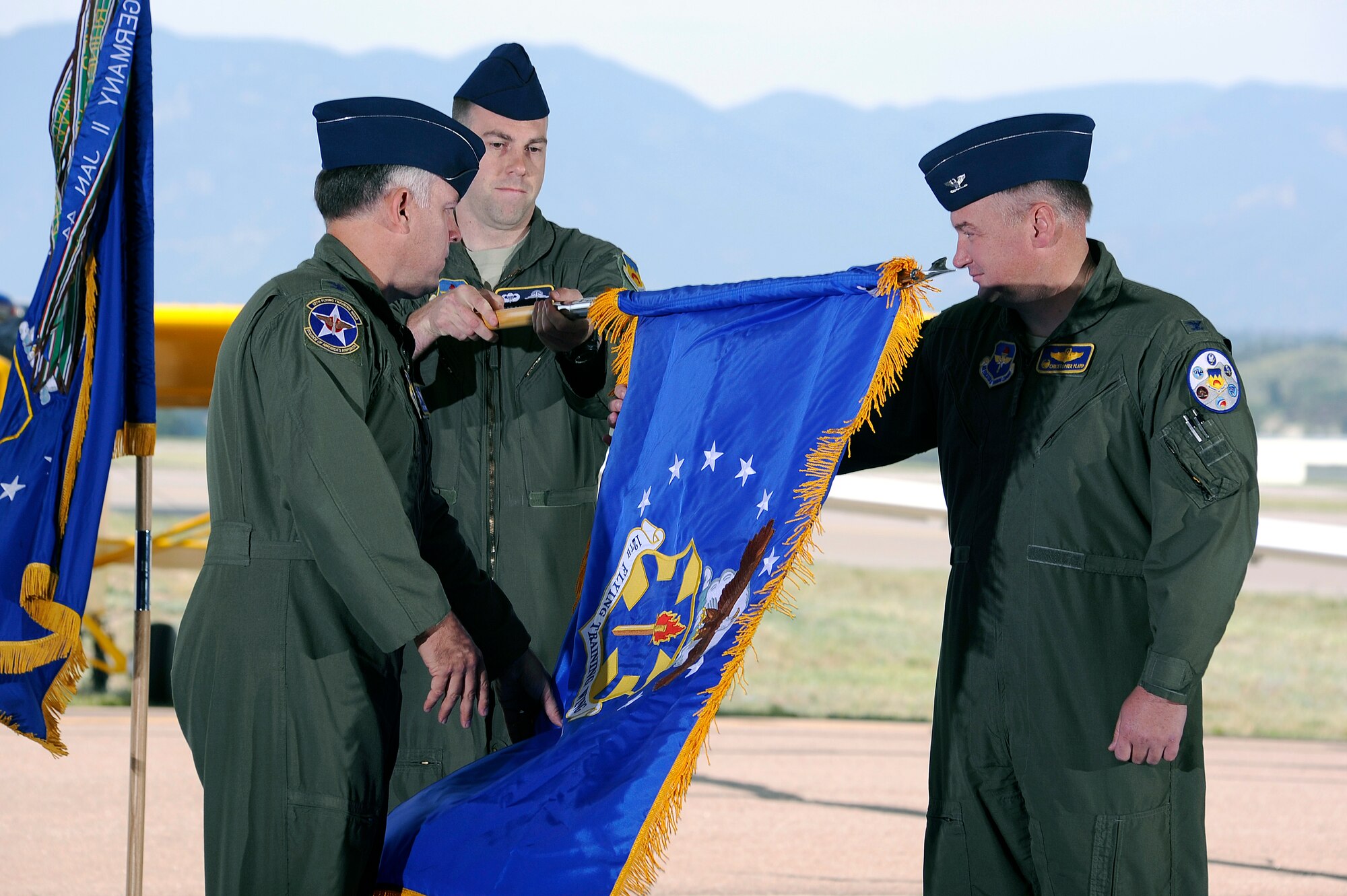 Col. Richard Murphy, commander 12th Flying Training Wing and Col. Richard Plamp, commander 306th Flying Training Group, U.S. Air Force Academy, Colo. uncases the 12th FTW flag during a redesignation ceremony at the Academy's airfield in Colorado Springs, Colo. June 6, 2012.   The 12th FTW took formal control of the group June 1 by order of Gen. Edward Rice, commander of Air Education and Training Command, due to the scheduled inactivation of the 19th Air Force.    (U.S. Air Force photo/Mike Kaplan) 