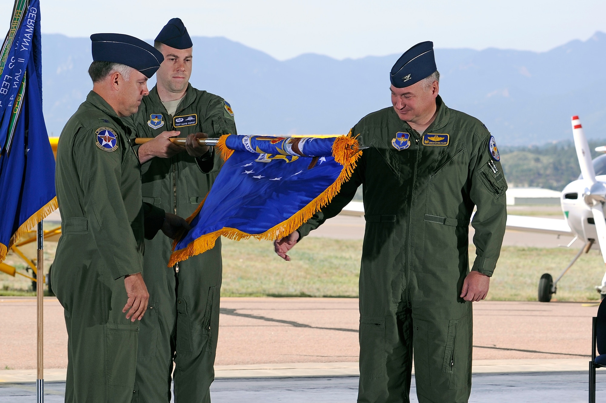 Col. Richard Murphy, commander 12th Flying Training Wing and Col. Richard Plamp, commander 306th Flying Training Group, U.S. Air Force Academy, Colo. uncases the 12th FTW flag during a redesignation ceremony at the Academy's airfield in Colorado Springs, Colo. June 6, 2012.   The 12th FTW took formal control of the group June 1 by order of Gen. Edward Rice, commander of Air Education and Training Command, due to the scheduled inactivation of the 19th Air Force.    (U.S. Air Force photo/Mike Kaplan) 