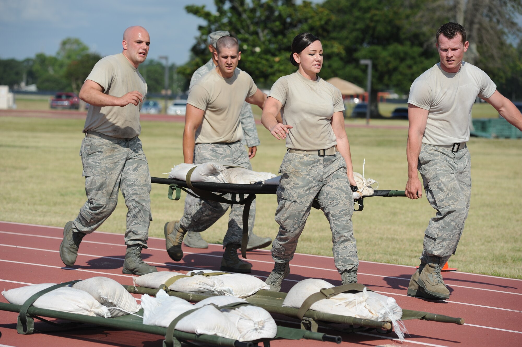 Senior Airman Aaron Ruschau, 1st Lt. Josh Anson, Senior Airman Patsy Chandler and Staff Sgt. Blaine Hunter, The Log Monsters from the 81st Logistics Readiness Squadron, complete the “Litter Carry” challenge during the 81st Mission Support Group Ultimate Warrior Challenge June 1, 2012, at the Triangle Track at Keesler Air Force Base, Miss.  The challenge consisted of retrieving four sandbags, placing them securely on a litter and carry to the next challenge starting point.  The challenge was held in honor of fellow service members who lost their lives in the fight for our nation’s freedom. It consisted of nine four-member teams racing in a competition designed to take them through various aspects of a deployment. The Ram Rods were the first place winners of the Ultimate Warrior Challenge.  (U.S. Air Force photo by Kemberly Groue)