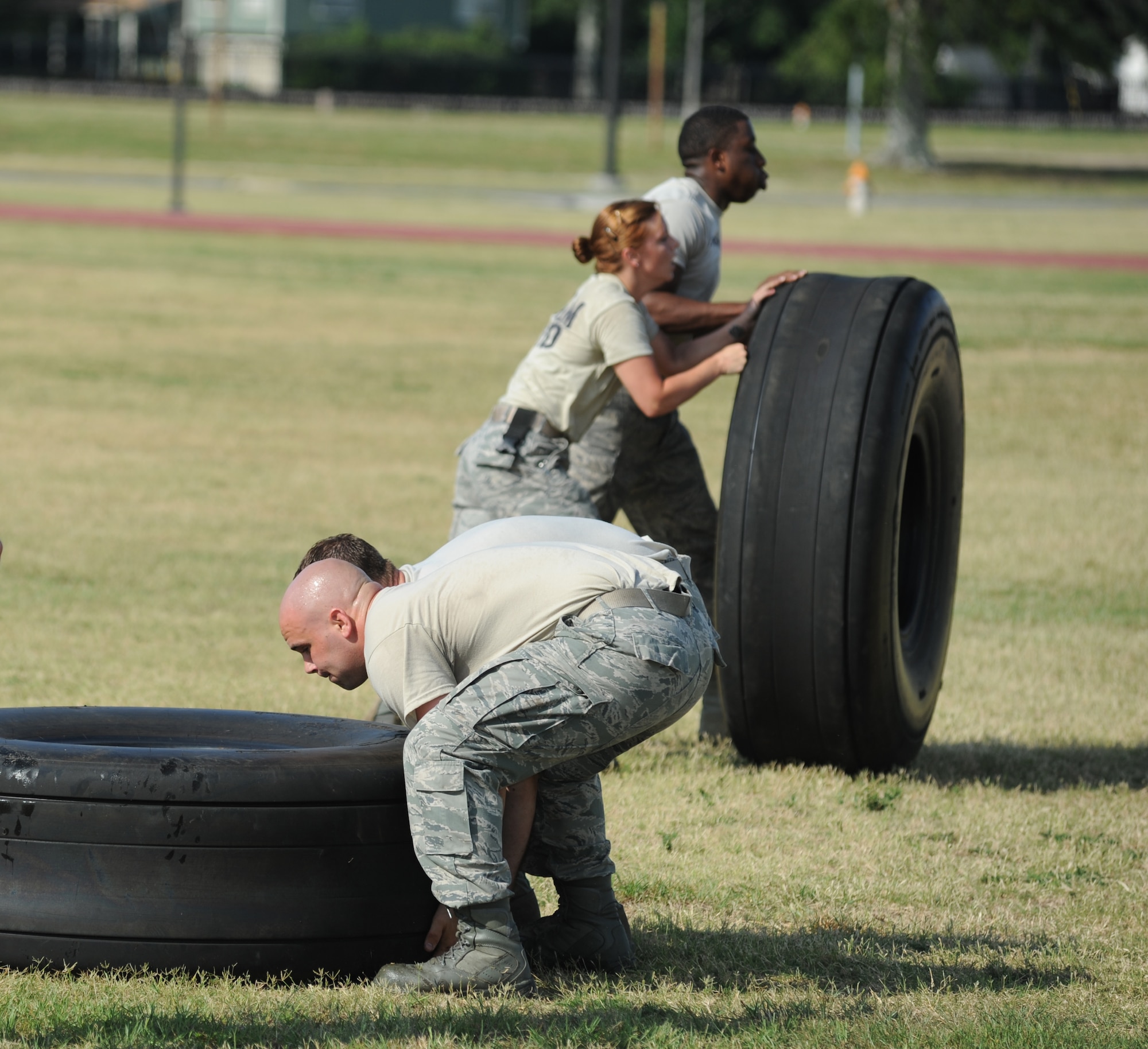 Senior Airman Aaron Ruschau and Staff Sgt. Blaine Hunter, The Log Monsters team members from the 81st Logistics Readiness Squadron, by-pass Ram Rod team members from the 81st Security Forces Squadron, Staff Sgt. Audrey Spoor and Senior Airman Justin Gachett in the “Tire Toss” challenge during the 81st Mission Support Group Ultimate Warrior Challenge June 1, 2012, at the Triangle Track at Keesler Air Force Base, Miss.  The challenge consists of two personnel flipping an aircraft tire to the designated location then the awaiting team members flipped it back to the start. The challenge was held in honor of fellow service members who lost their lives in the fight for our nation’s freedom. It consisted of nine four-member teams racing in a competition designed to take them through various aspects of a deployment. The Ram Rods were the first place winners of the Ultimate Warrior Challenge.  (U.S. Air Force photo by Kemberly Groue)