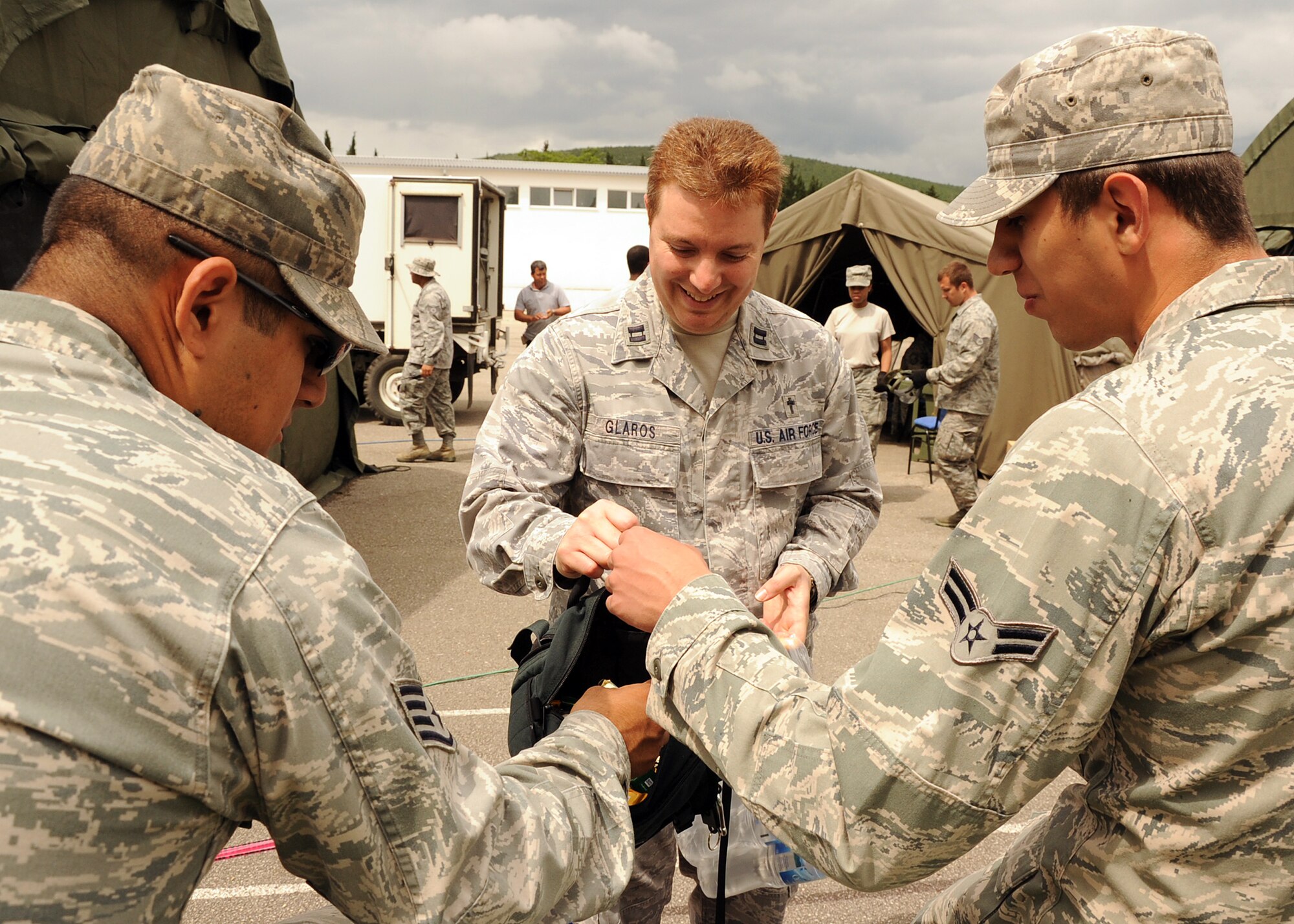 CAPLJINA, Bosnia and Herzegovina -- Chaplain (Capt.) Matt Glaros, 48th Fighter Wing, dispenses candy and water during Shared Resilience 2012, June 5. During the two-week exercise, Glaros and Tech. Sgt. Andrew Morgan, 48th FW chaplain assistant, organized church services and activities for service members. More than 500 military members from nine nations are participating in SR12, an annual U.S. Joint Chiefs of Staff-sponsored medical exercise, May 28 - June 8. The goals of the exercise are to strengthen interoperability, facilitate training in crisis response and disaster management, and validate the readiness of deployable military medical and humanitarian assistance teams. The exercise, in the spirit of partnership for peace, directly supports U.S. European Command's theater cooperation efforts and strategy for active security with European countries. (U.S. Air Force photo by Staff Sgt. Daryl Knee)