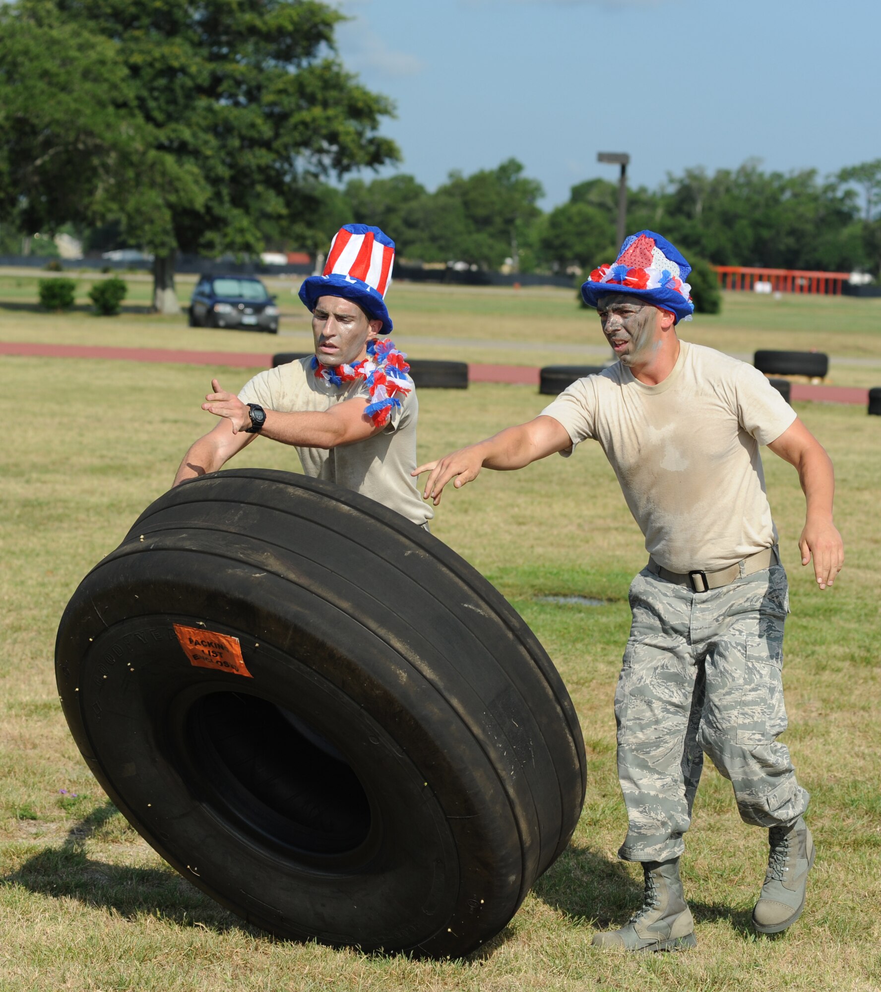 First Lt. Kyle Davis and Staff Sgt. Marc Skinner, members of the Logitators team from the 81st Logistics Readiness Squadron, work together in the “Tire Toss” challenge, which consists of two personnel flipping an aircraft tire from start to the designated location then the remaining team members flipping it back to during the 81st Mission Support Group Ultimate Warrior Challenge June 1, 2012, at the Triangle Track at Keesler Air Force Base, Miss.  The challenge was held in honor of fellow service members who lost their lives in the fight for our nation’s freedom. It consisted of nine four-member teams racing in a competition designed to take them through various aspects of a deployment.   (U.S. Air Force photo by Kemberly Groue)